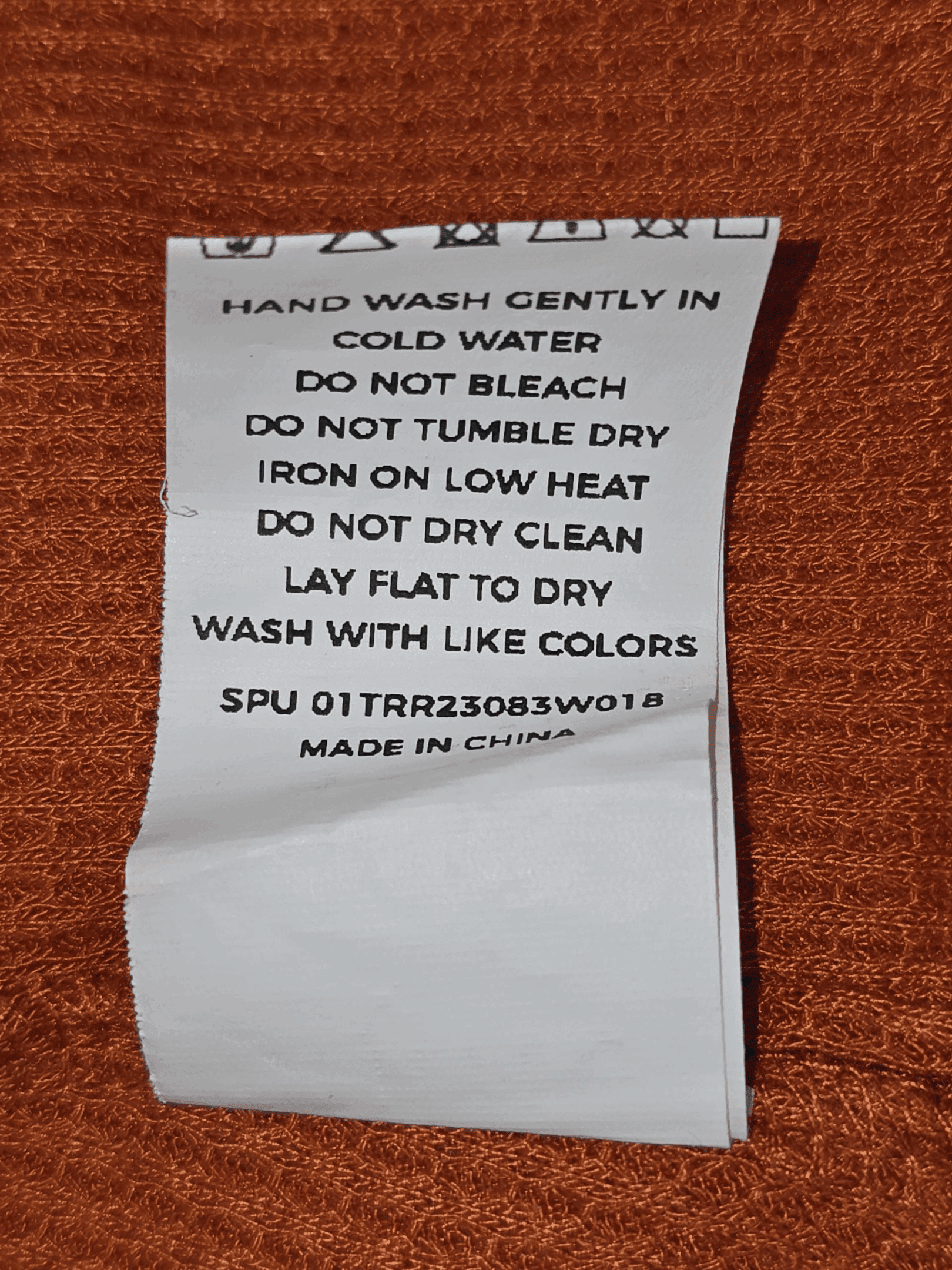 Clothing care label with washing and drying instructions.