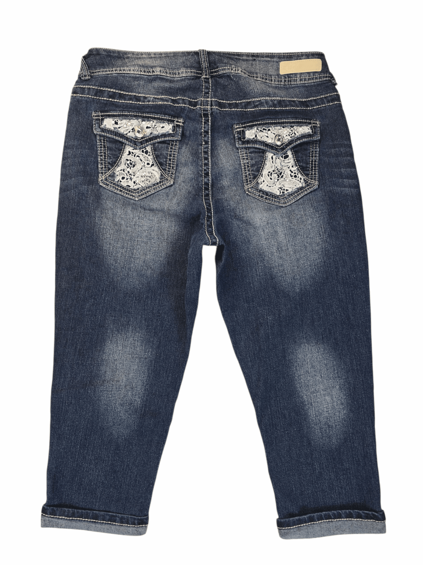 Back view of Wallflower blue denim capris showing embellished back pockets with lace and rhinestone accents.