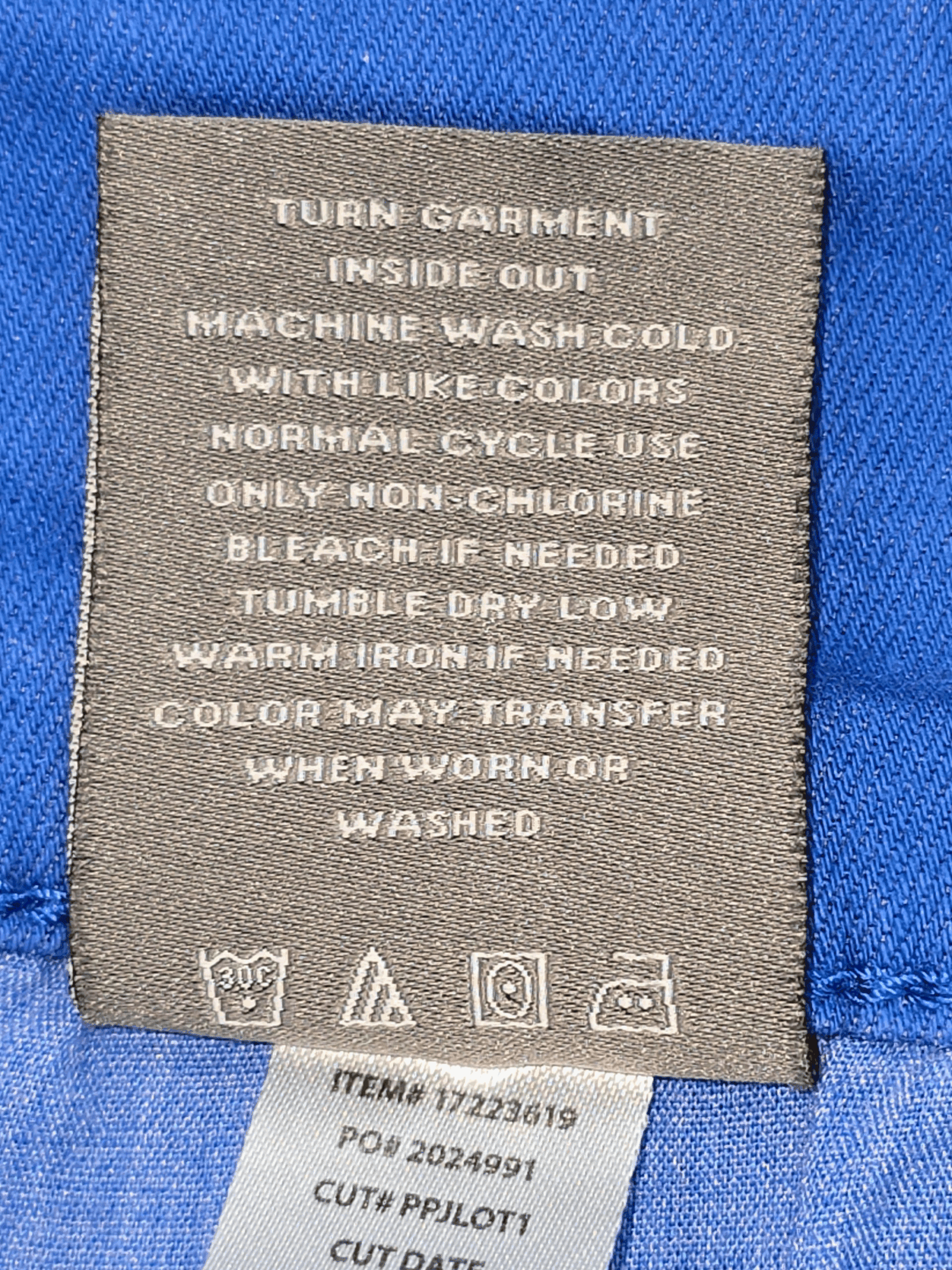 Clothing care label with washing and ironing instructions.