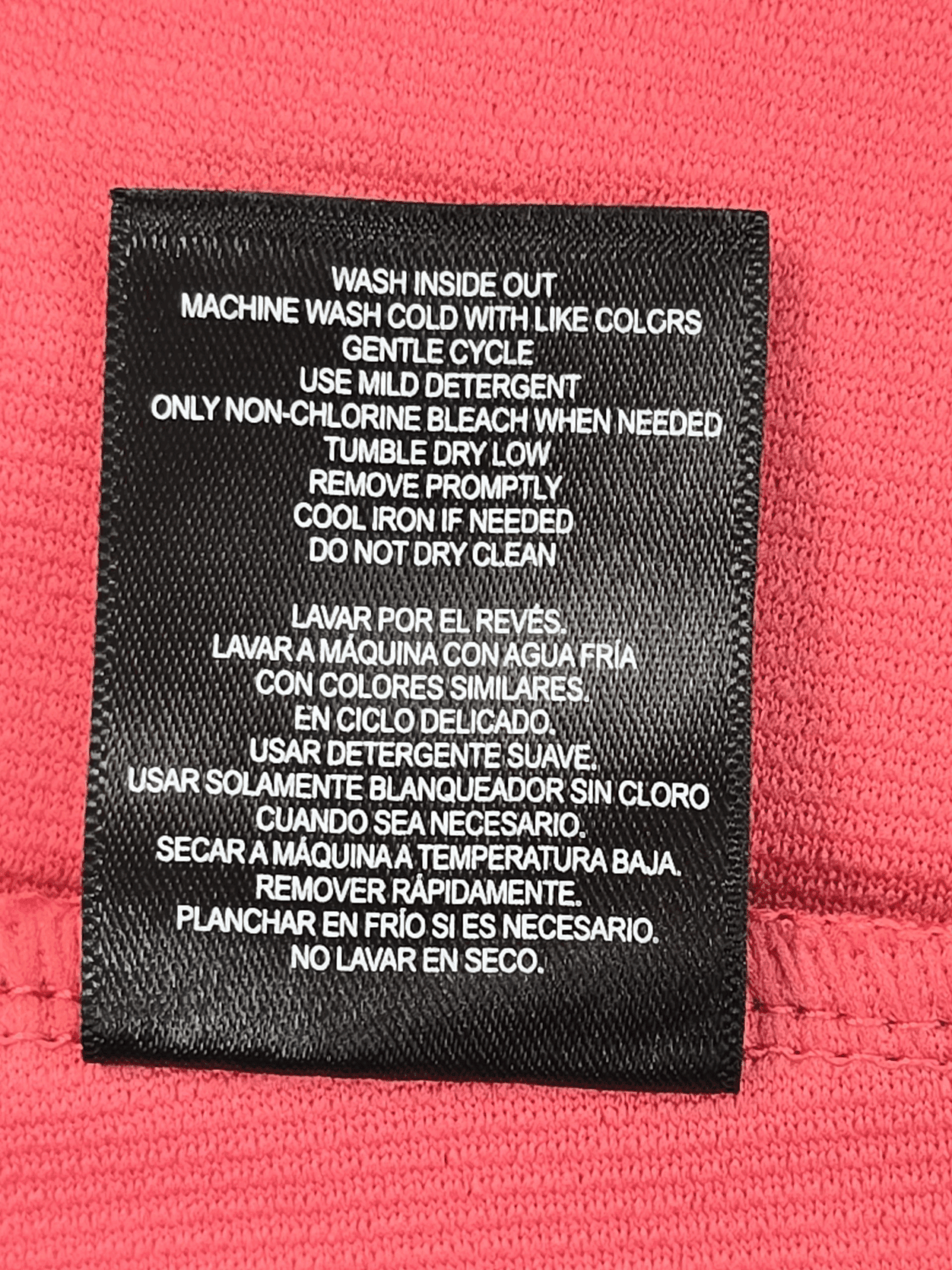 Clothing care label with washing and drying instructions in multiple languages.