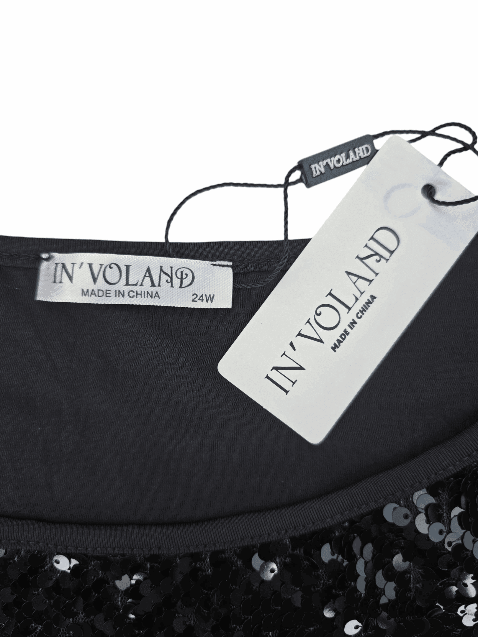 Clothing tags showing brand and size on a black sequined garment.