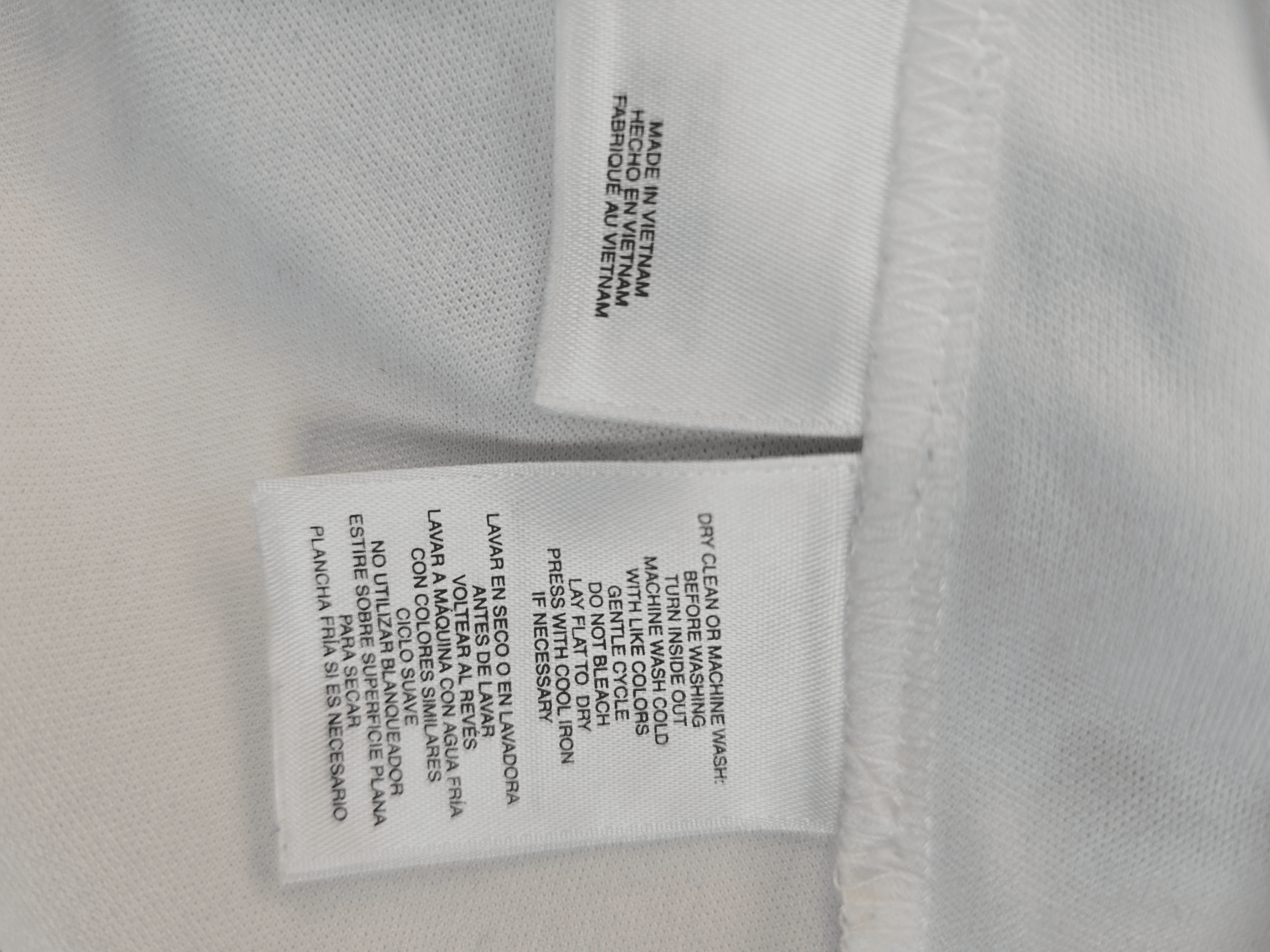 Close-up of clothing care labels with fabric and washing instructions.