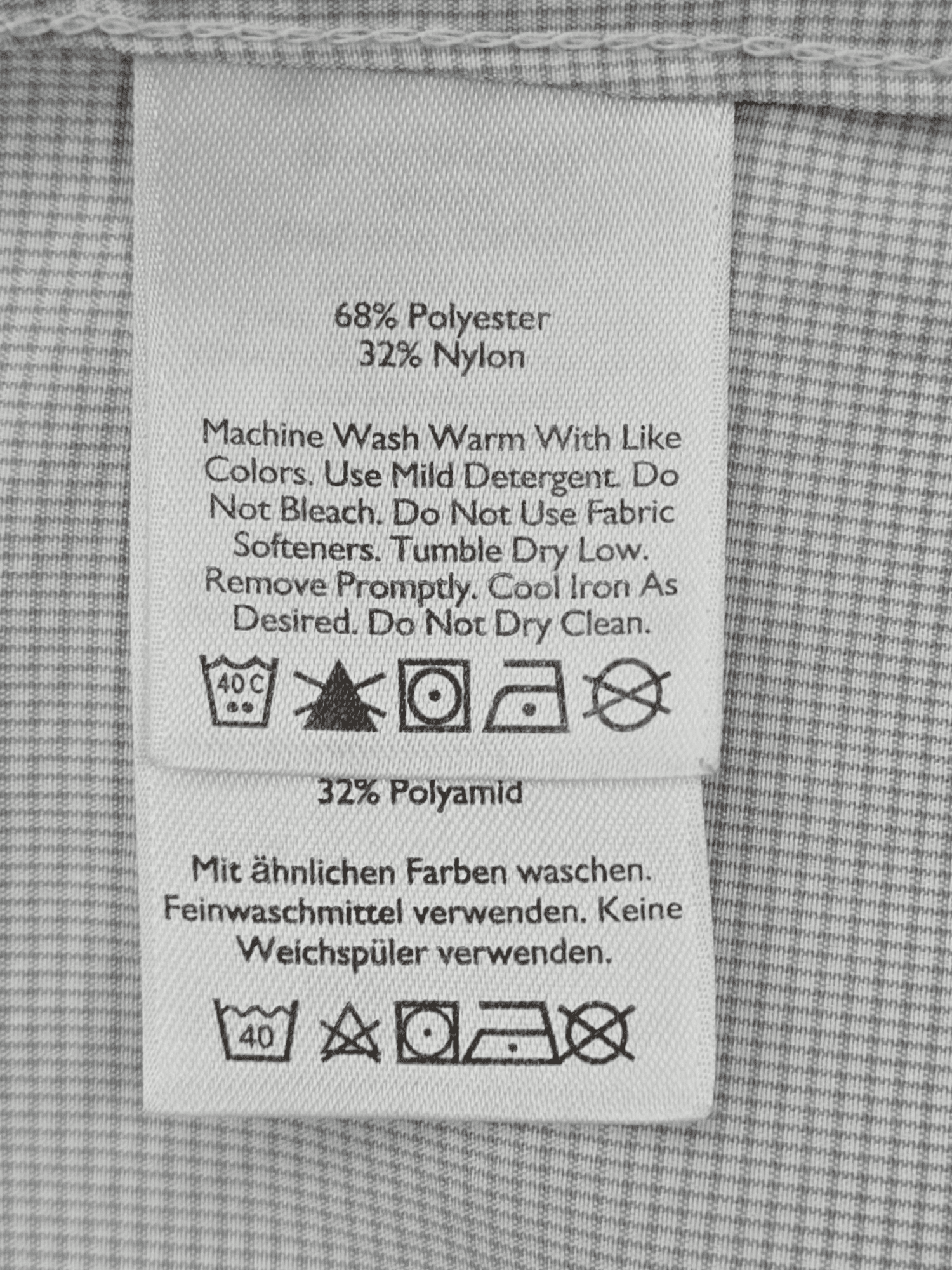 Material content tag listing polyester and spandex blend for Eddie Bauer light blue checked performance shirt.