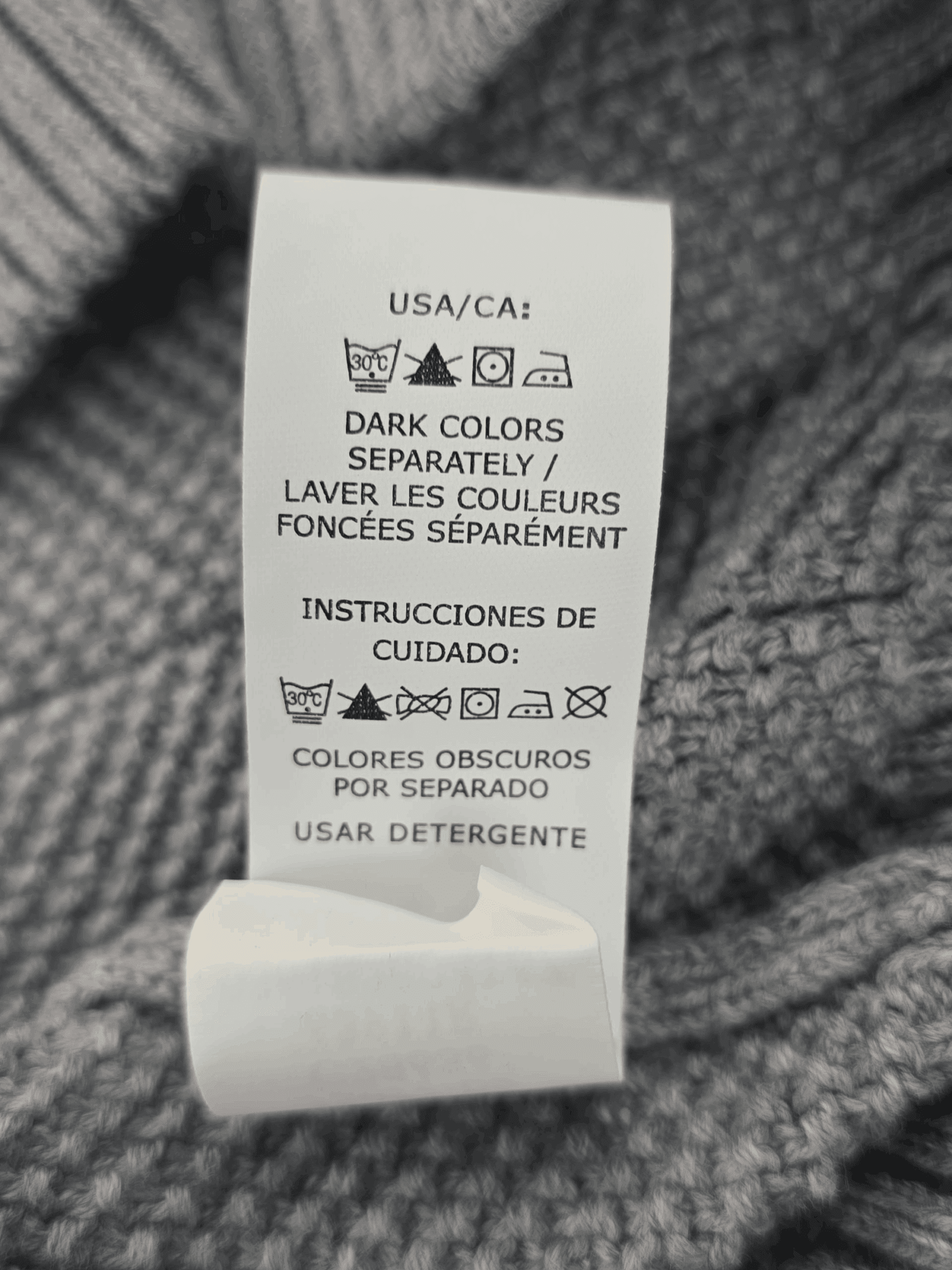 Clothing care label with washing instructions in English and Spanish.