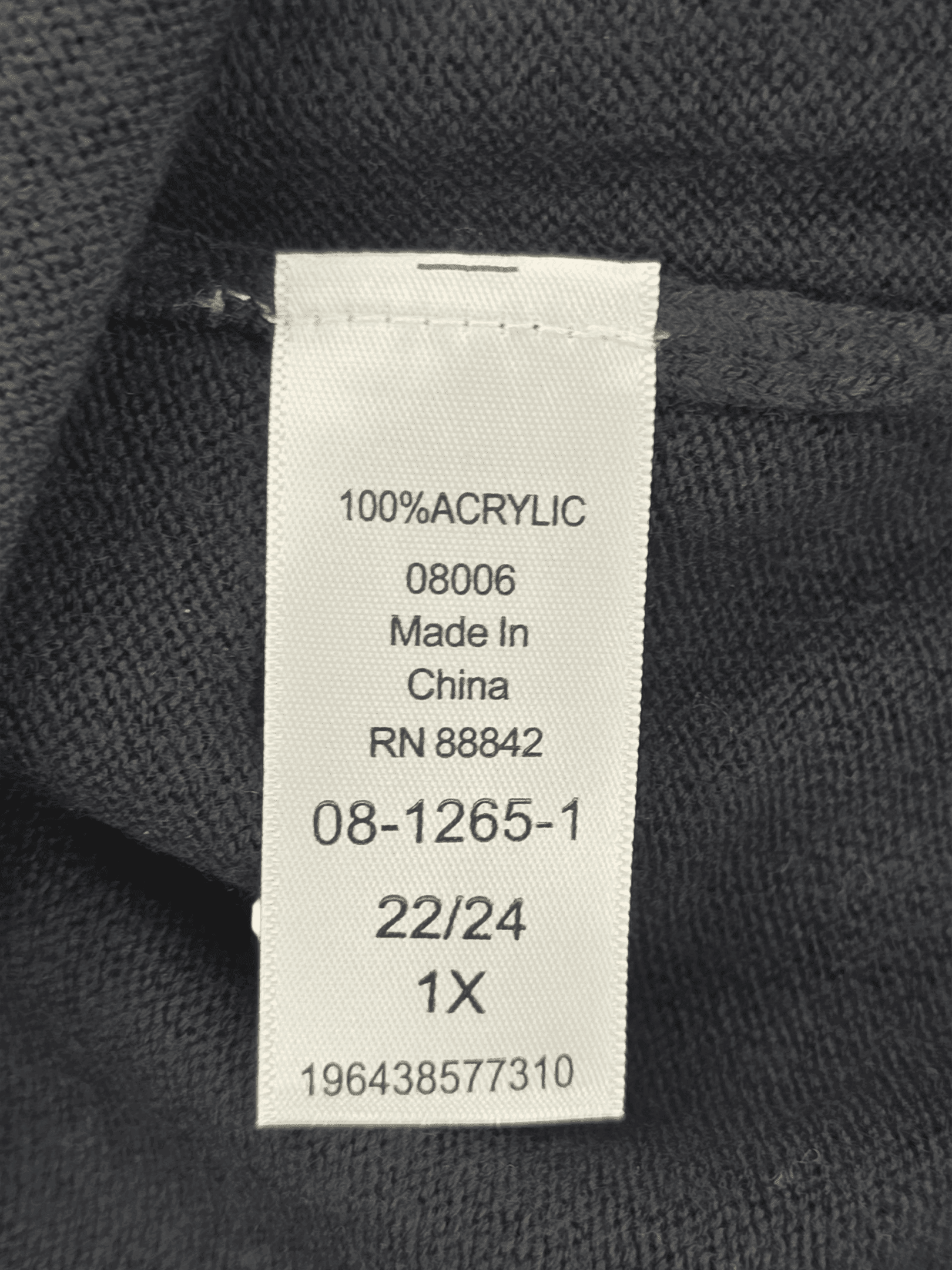 Clothing tag showing material, origin, and size details.