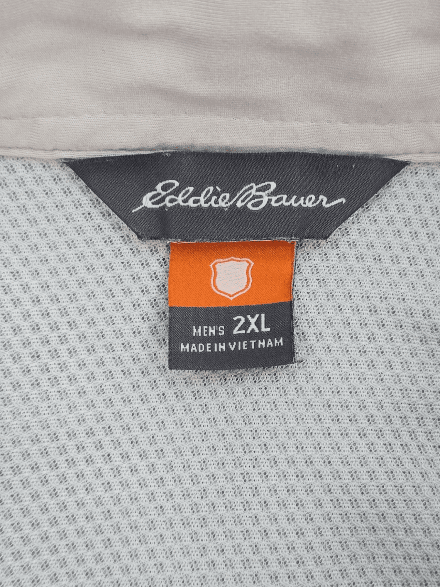 Eddie Bauer brand and size tag on light blue checked performance shirt in men’s size 2XL.