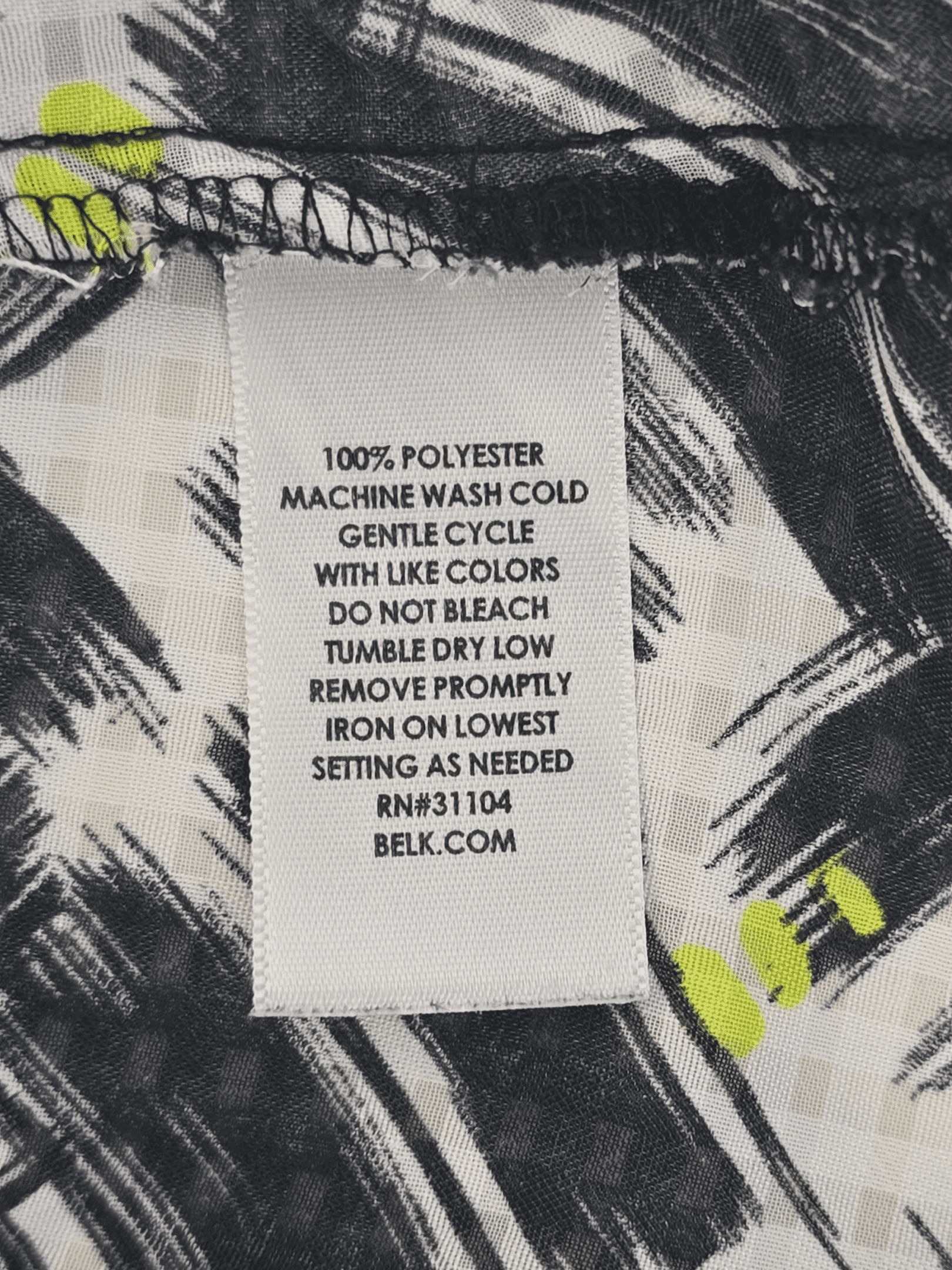 Material content tag listing polyester blend for Kim Rogers black and white paint stroke roll tab top.