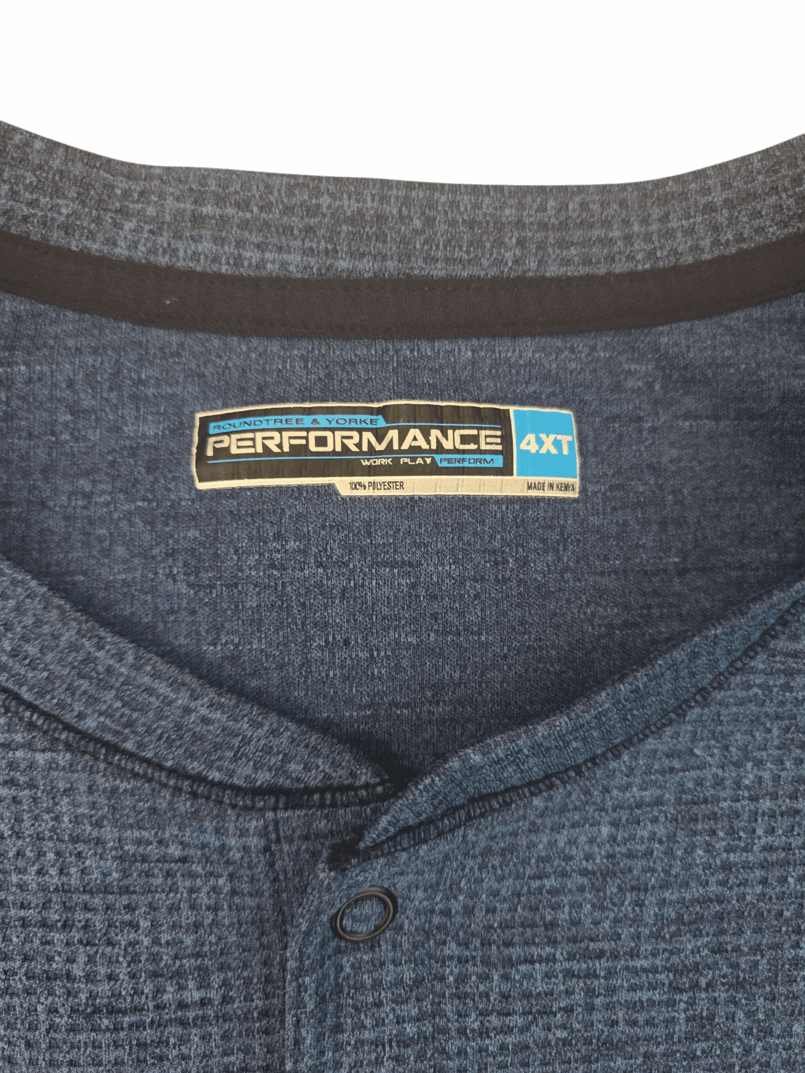 Close-up of a Performance brand clothing label on a blue textured shirt.