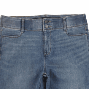 Close-up of blue denim jeans front with button and pockets.