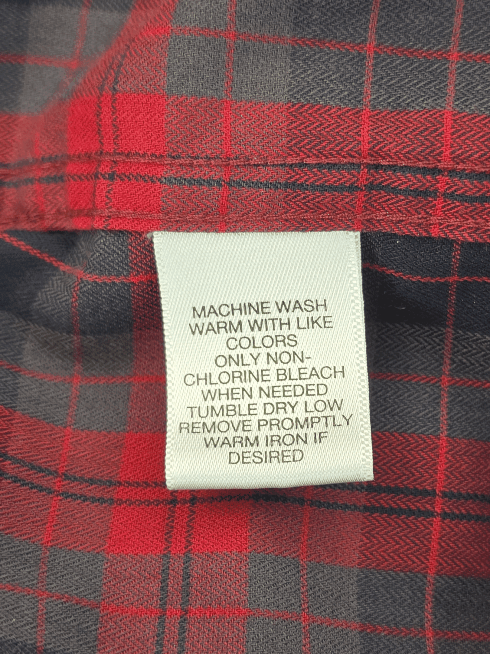 Close-up of a clothing care label with washing instructions.