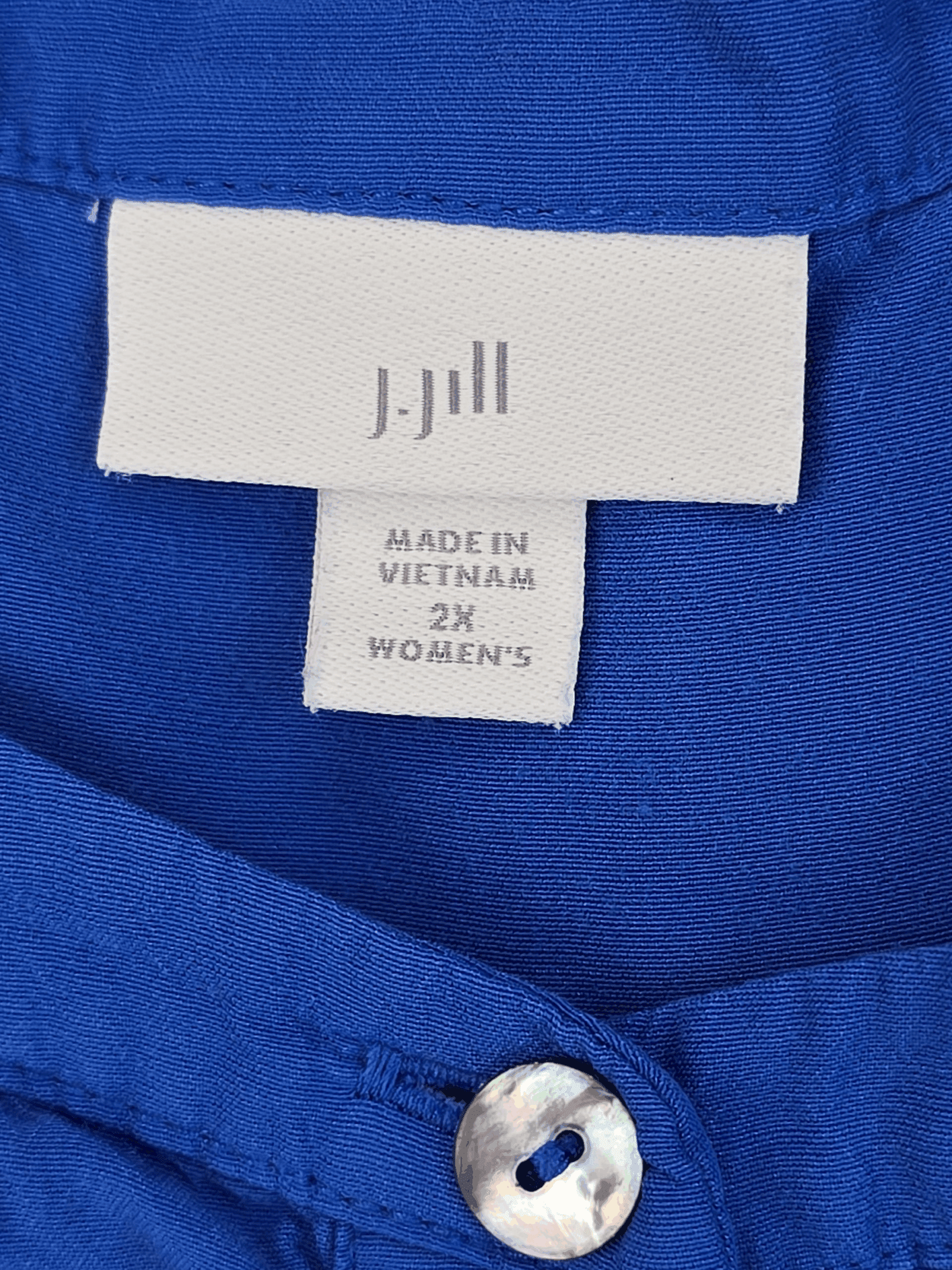 Label on a blue garment indicating size 2XL and made in Vietnam.