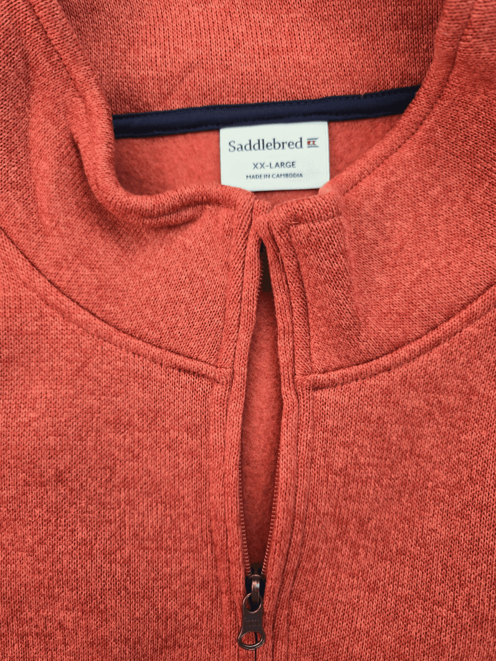 Close-up of Saddlebred rust quarter-zip knit pullover front showing zipper, collar, and knit texture.