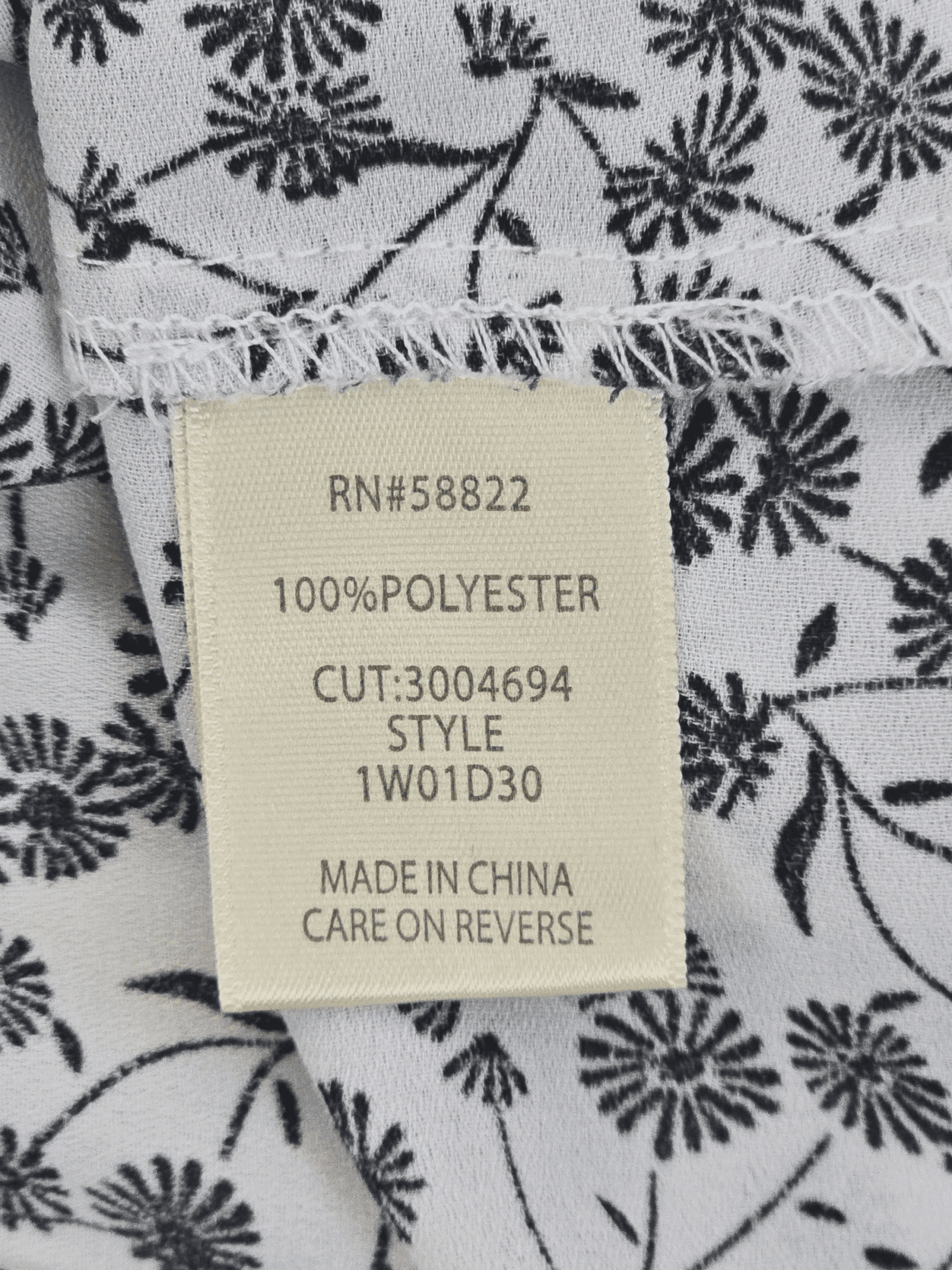 Clothing tag with fabric and manufacturing details.