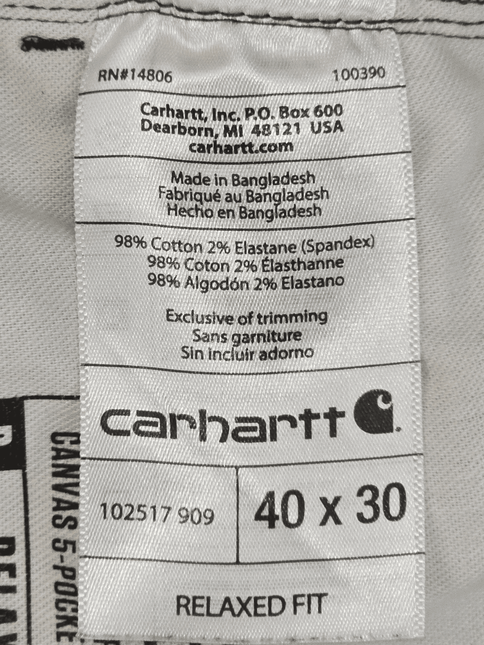 Carhartt clothing label showing size and material details.