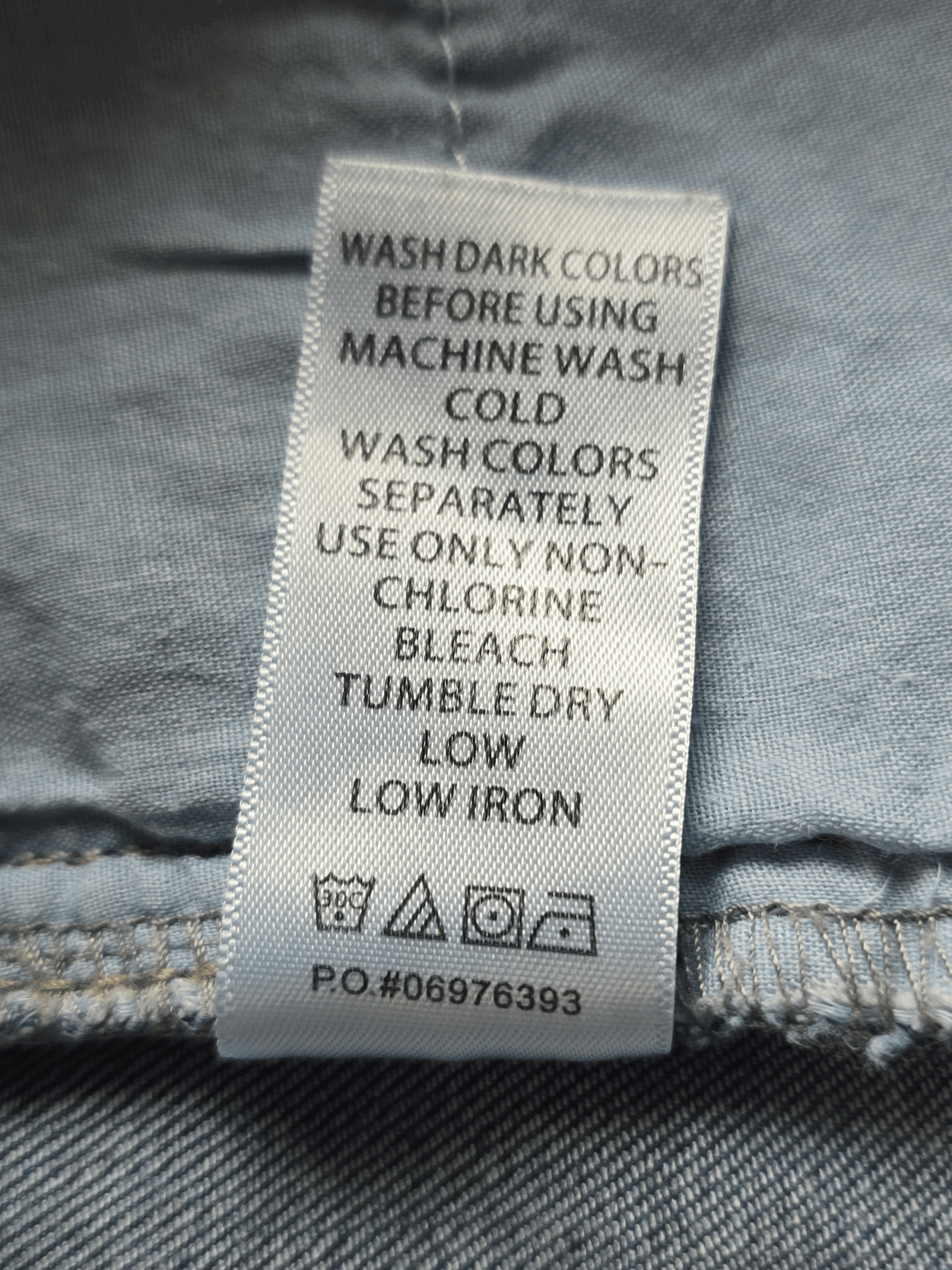 Clothing care label with washing and ironing instructions.