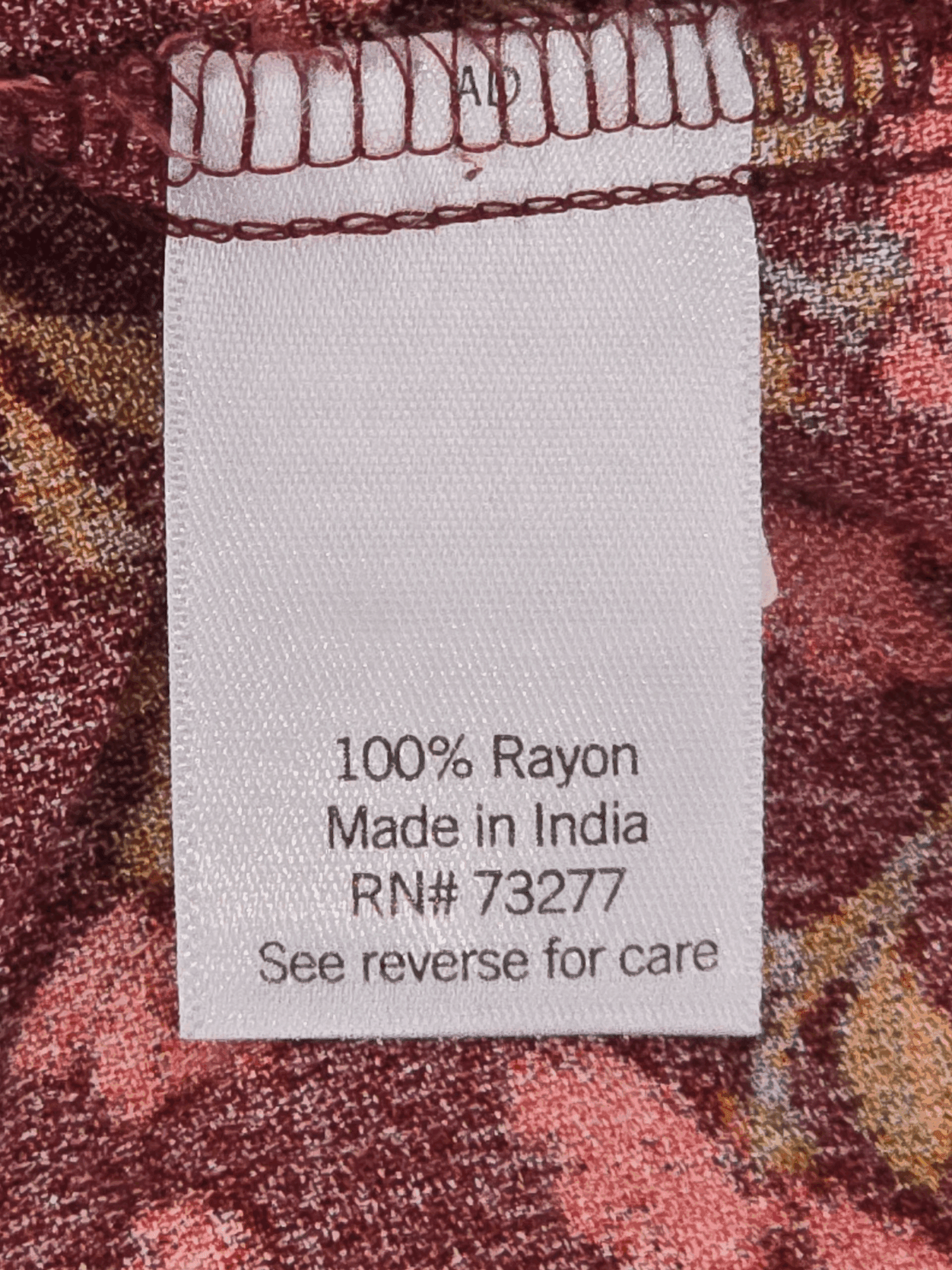 Material content tag listing fiber composition for Sonoma rust floral rayon pullover top.