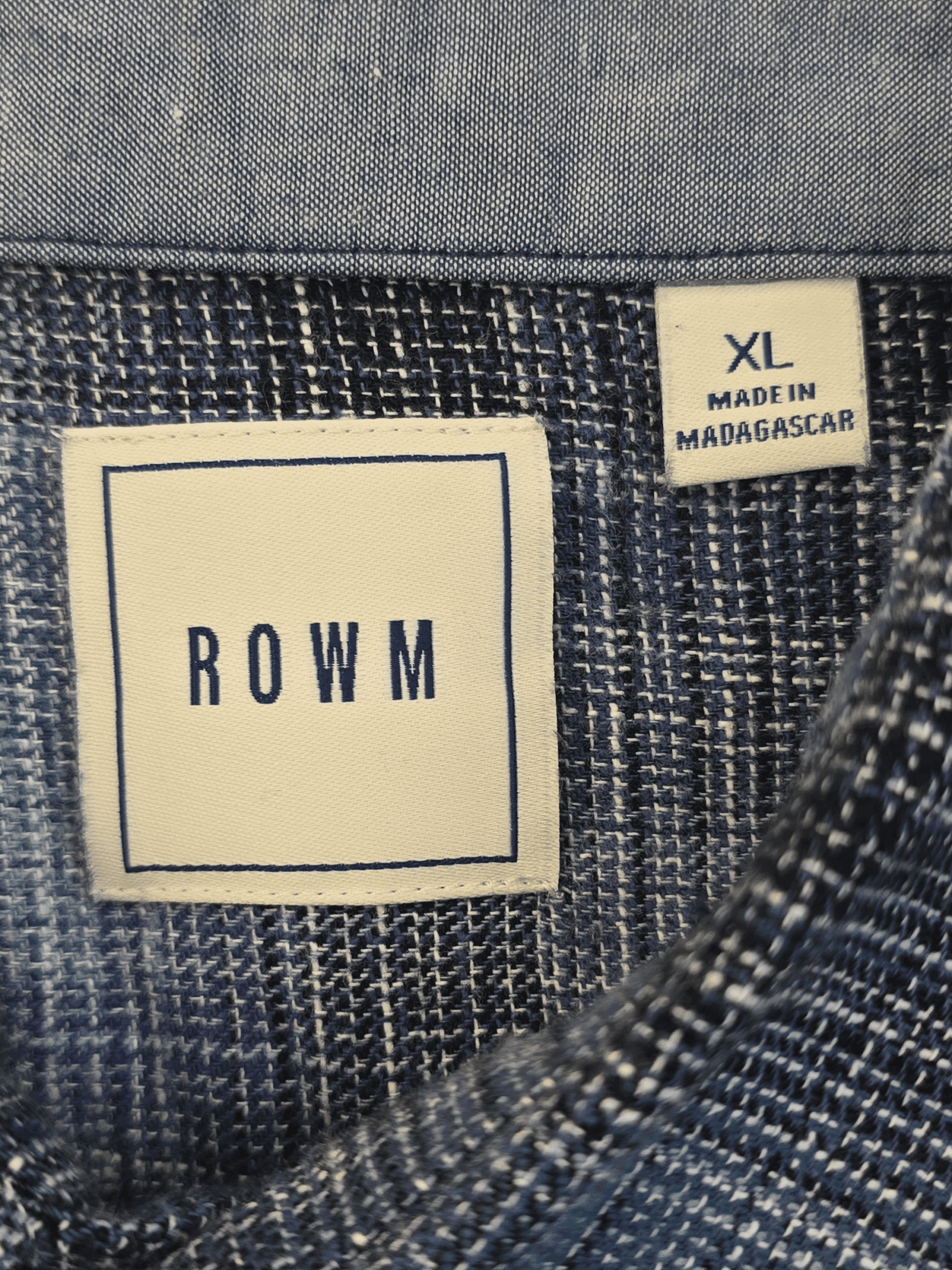 Clothing label showing brand ROWM and size XL made in Madagascar.