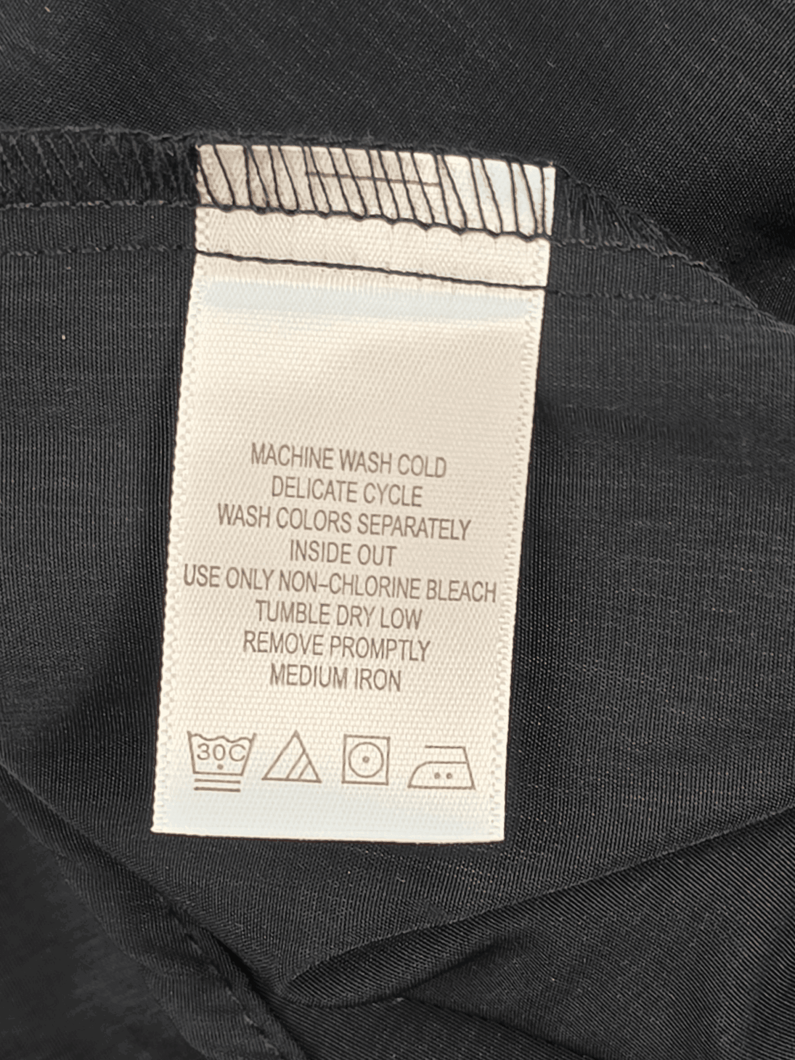 Garment care tag for Only Necessities black button-up shirt showing washing and drying directions.
