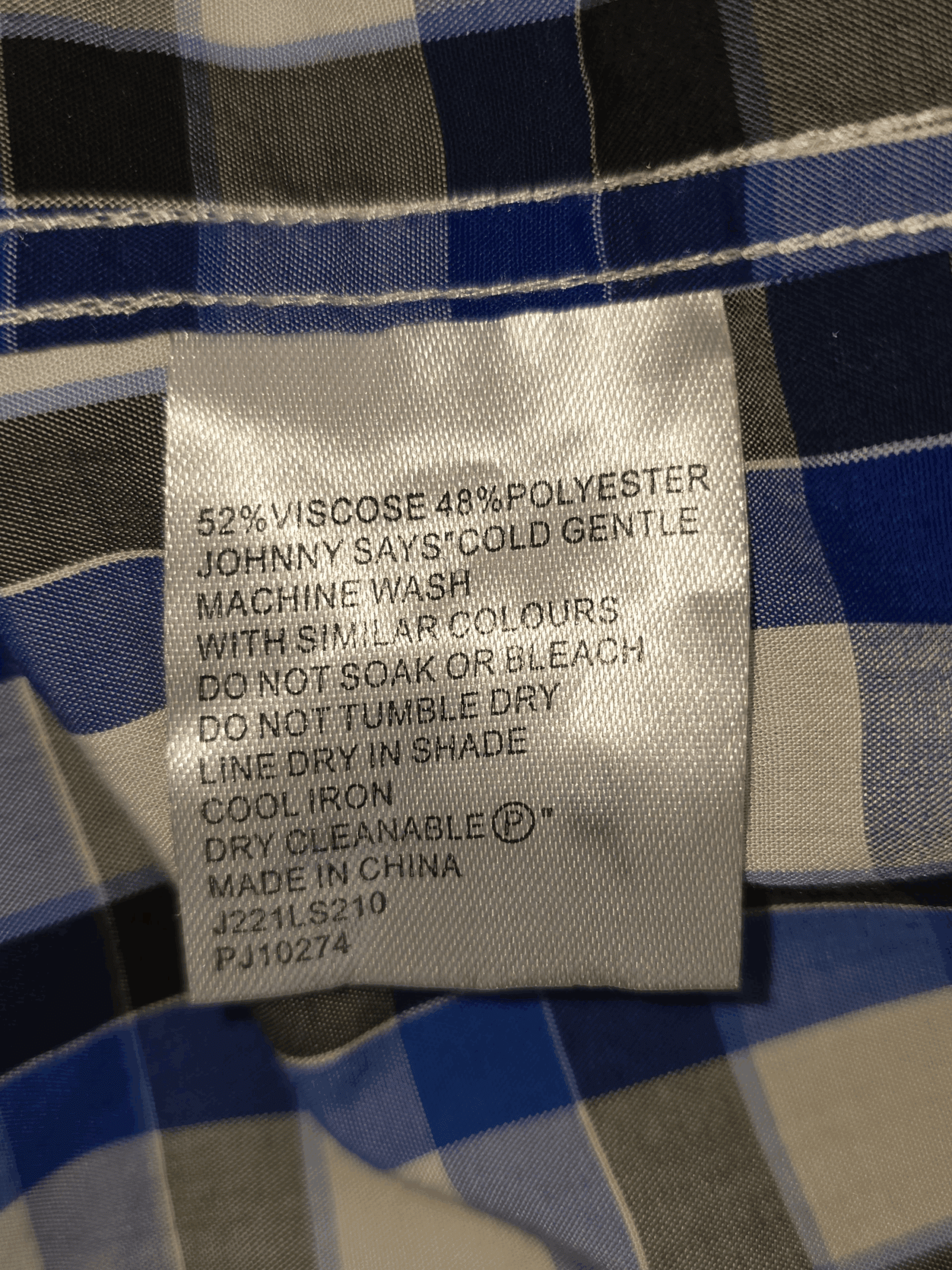 Clothing care label with washing instructions and material composition.