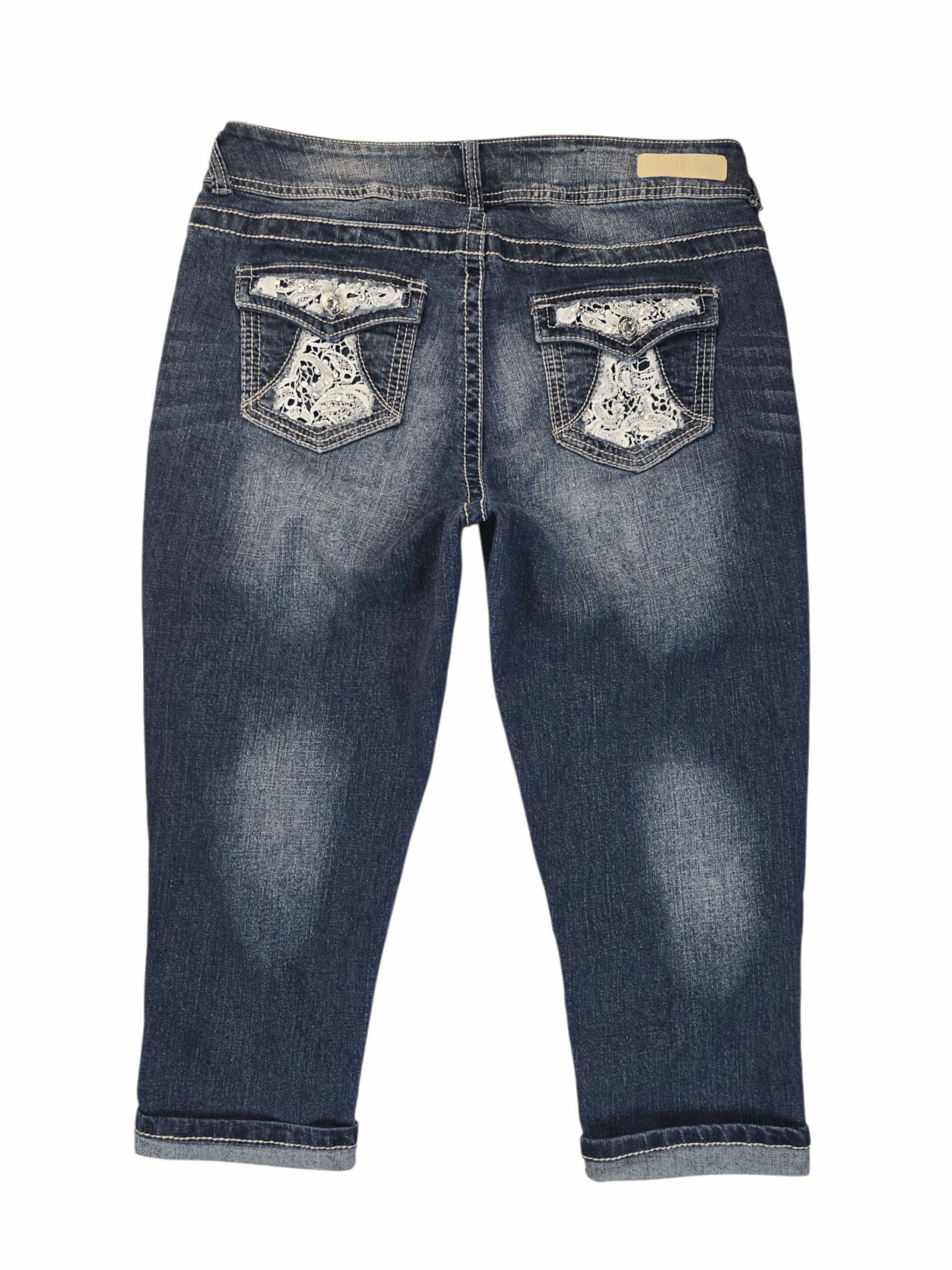 Back view of Wallflower blue denim capris showing embellished back pockets with lace and rhinestone accents.