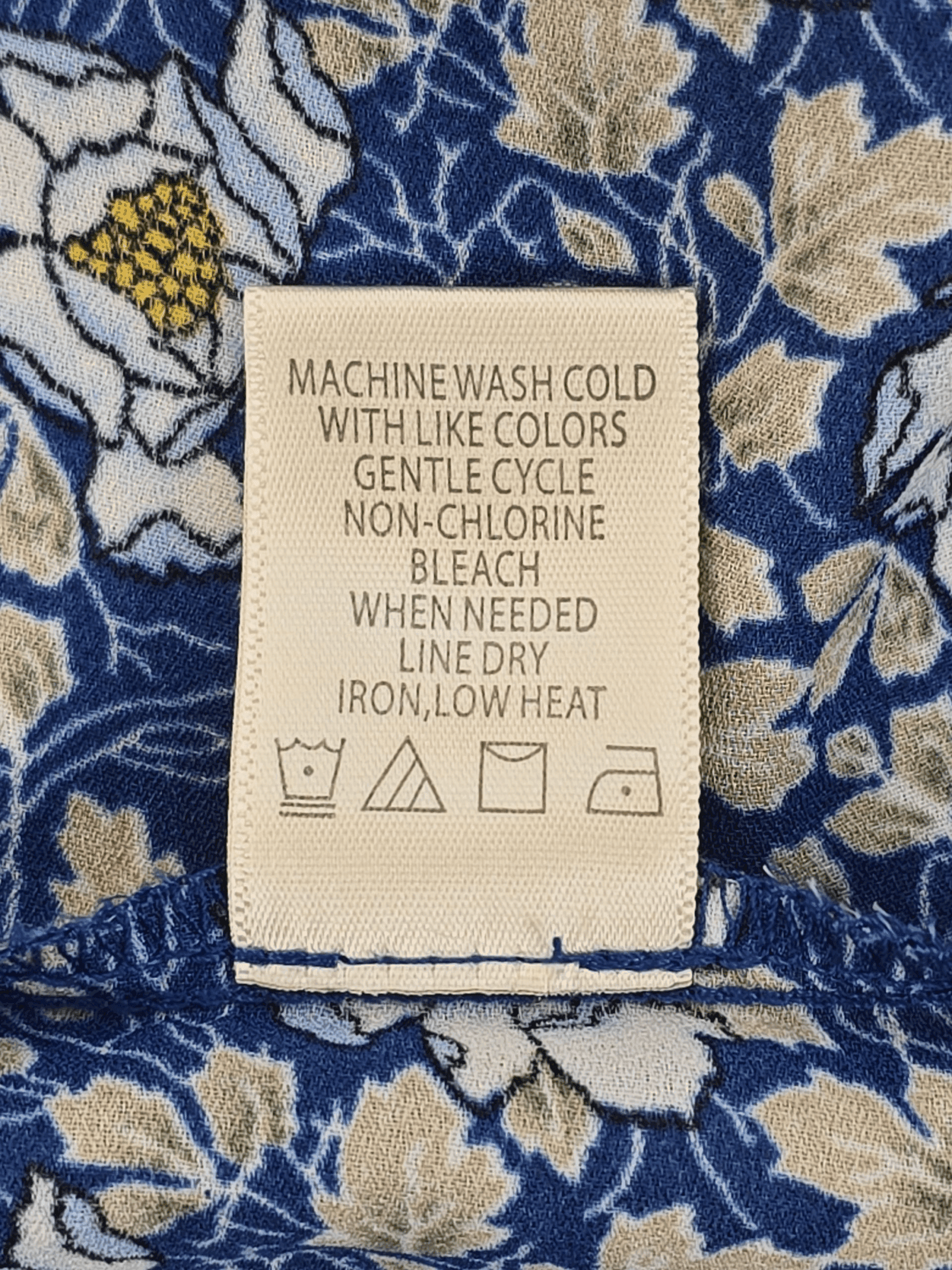 Clothing care label with washing and ironing instructions.