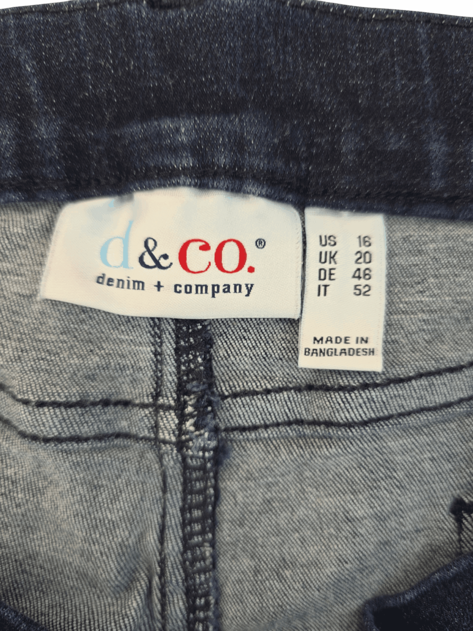 D&Co brand and size tag on pull-on blue jeans with faux fly in women’s size 16.