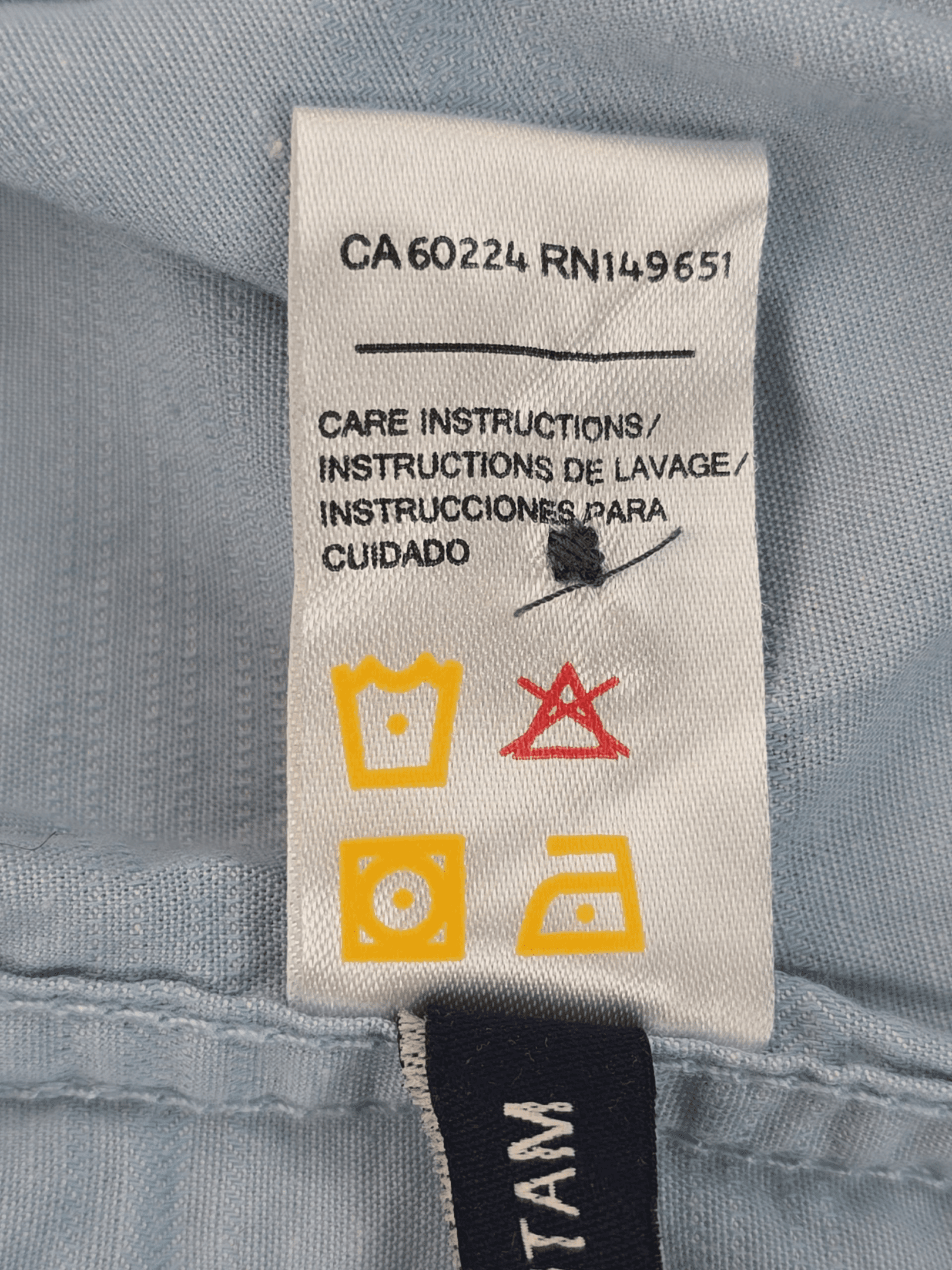 Care instructions label with washing, drying, and ironing symbols.