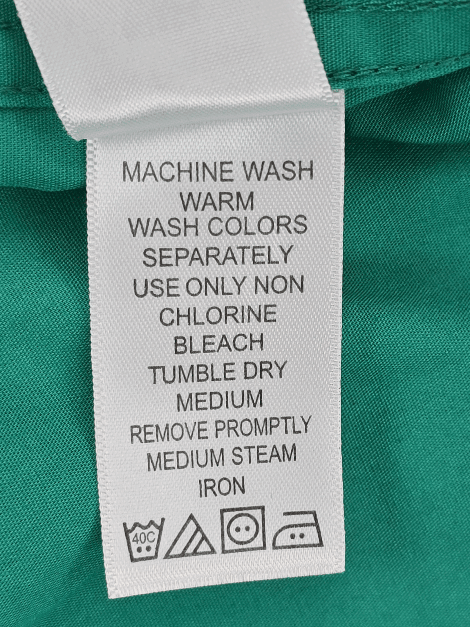 Clothing care label with washing and ironing instructions.