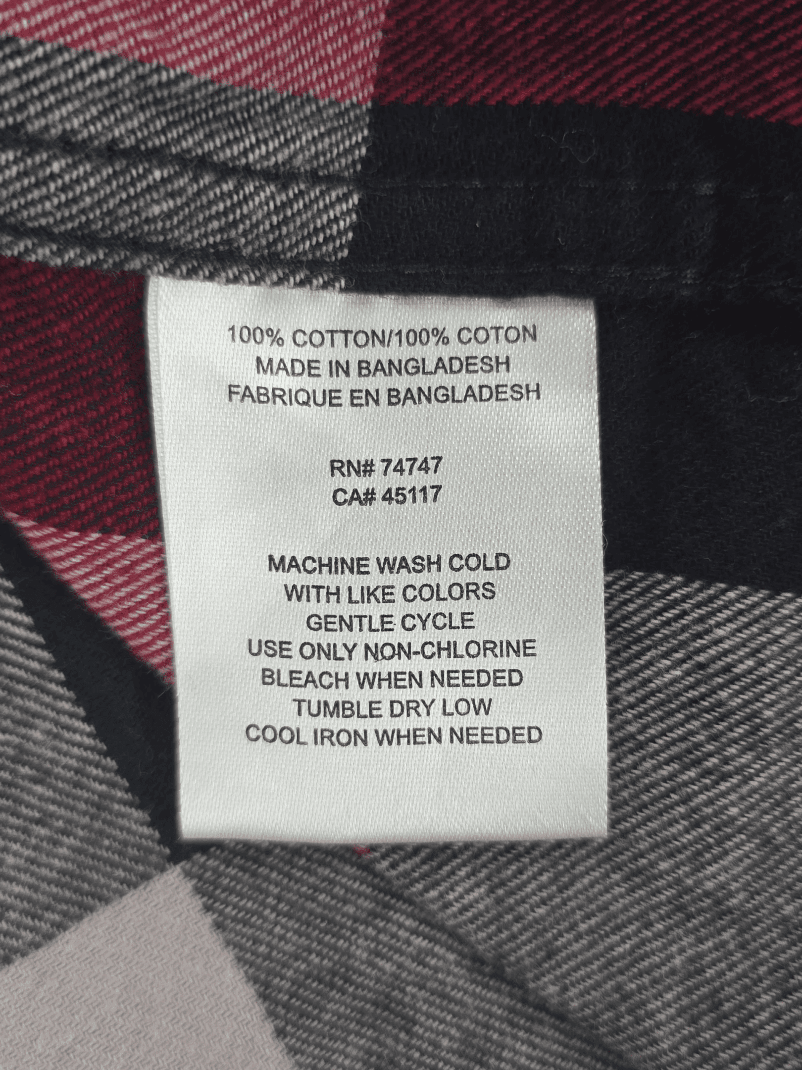 Material content tag listing 100% cotton for Red Head red, black, and gray plaid flannel button-up shirt.