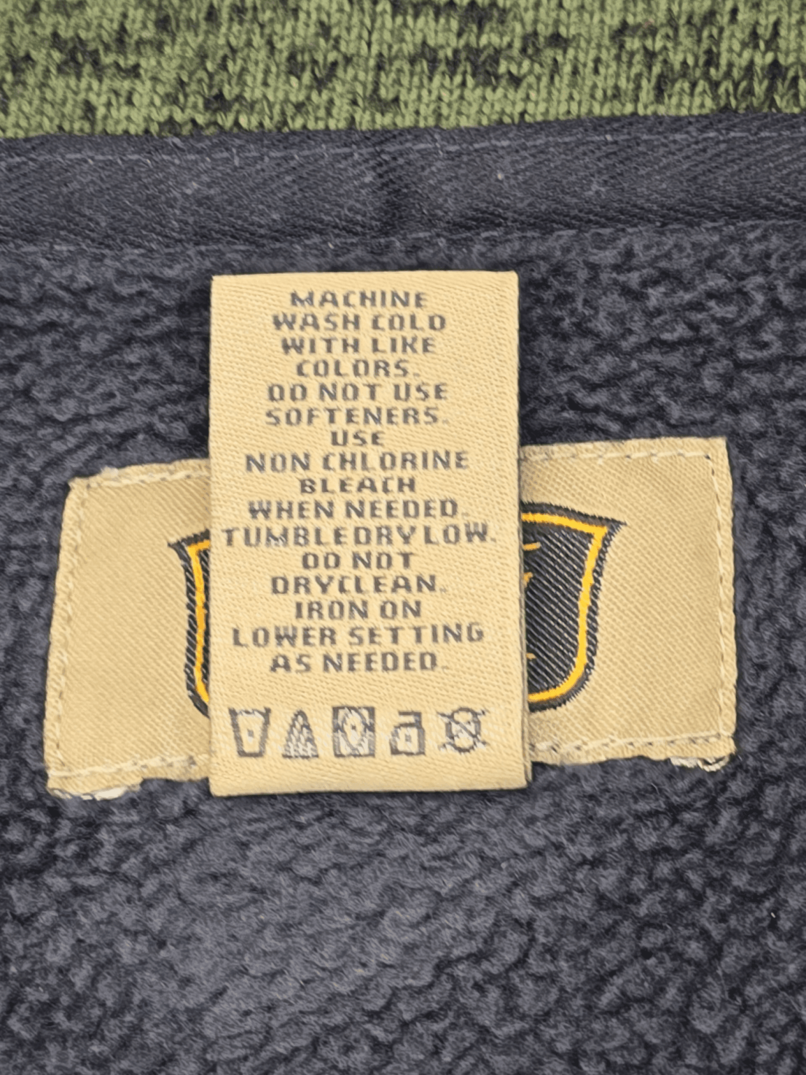 Clothing care label with washing and drying instructions on a denim fabric.