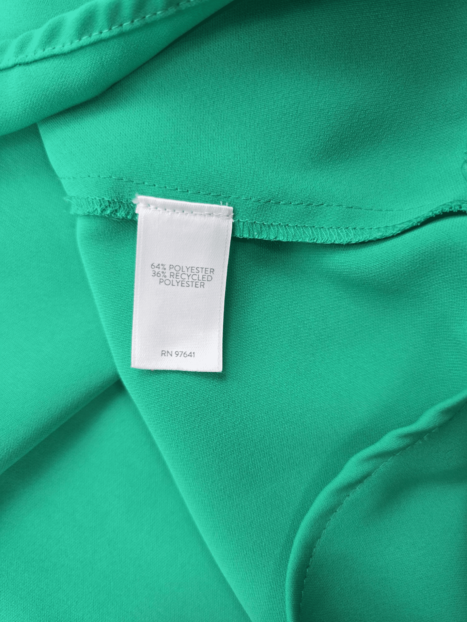 Material content tag listing rayon, nylon, and spandex blend for J. Jill Wearever Collection green pullover top.
