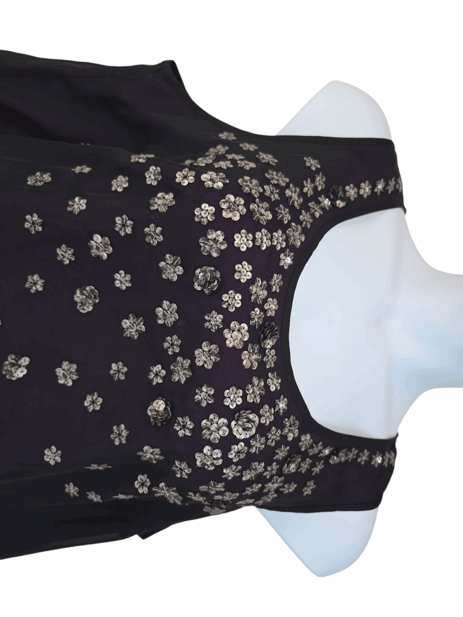 Black sleeveless blouse with gold floral embroidery.
