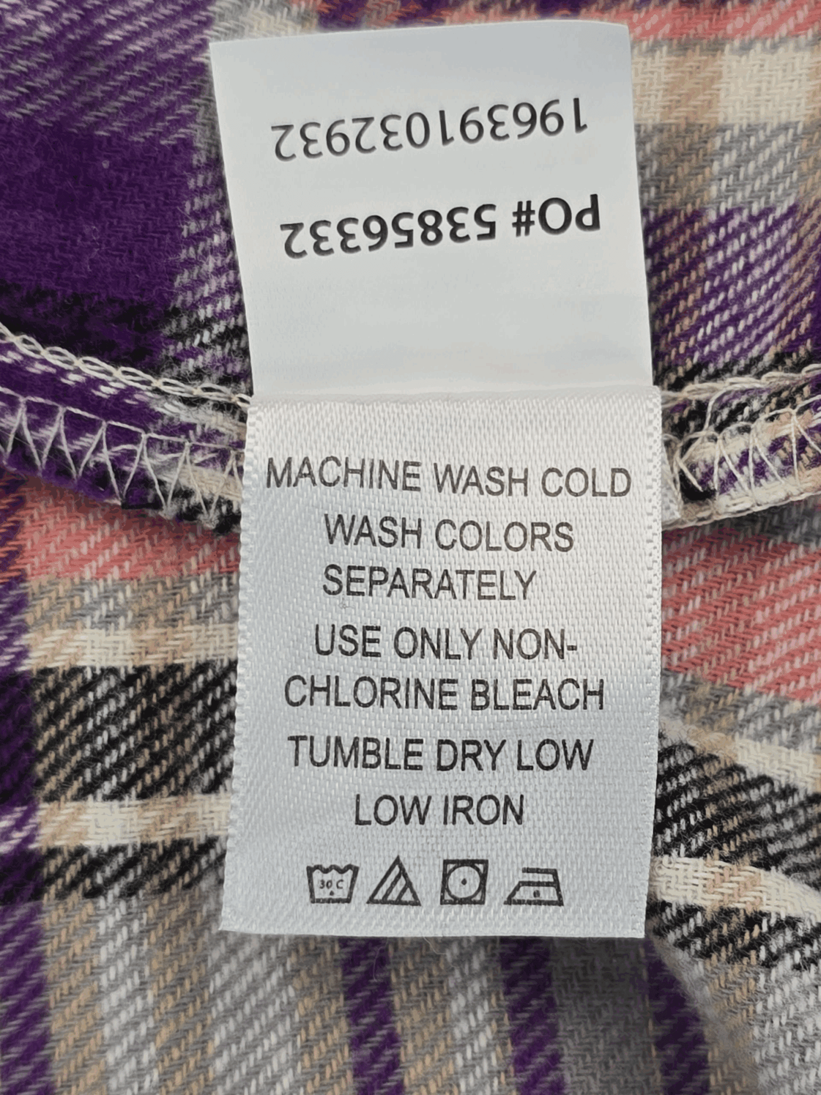 Garment care tag for Woman Within purple and pink plaid flannel button-up shirt showing washing and drying directions.