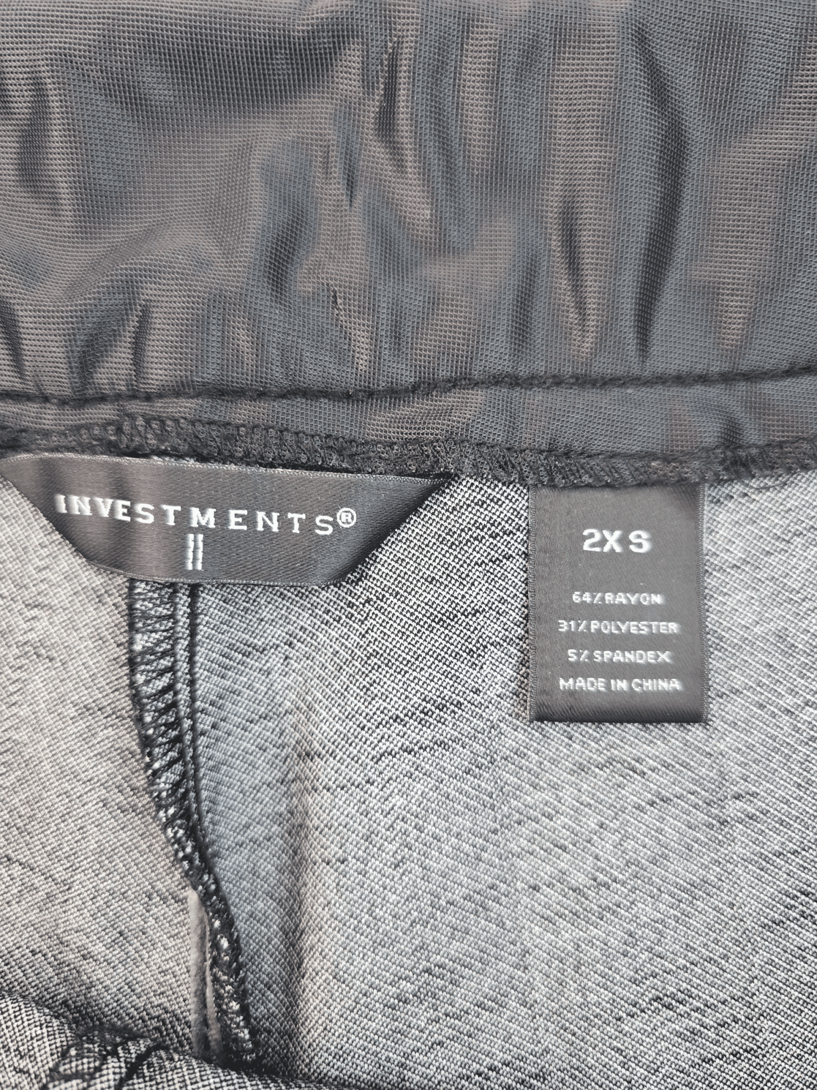 Clothing label showing size and care instructions inside a garment.