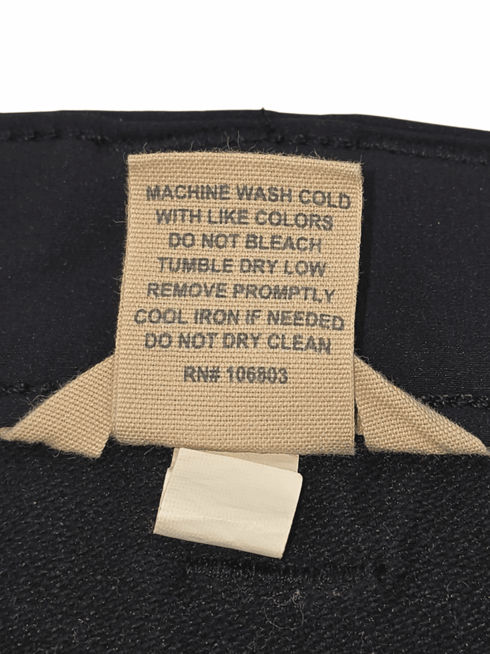 Clothing care label with washing instructions and fabric details.