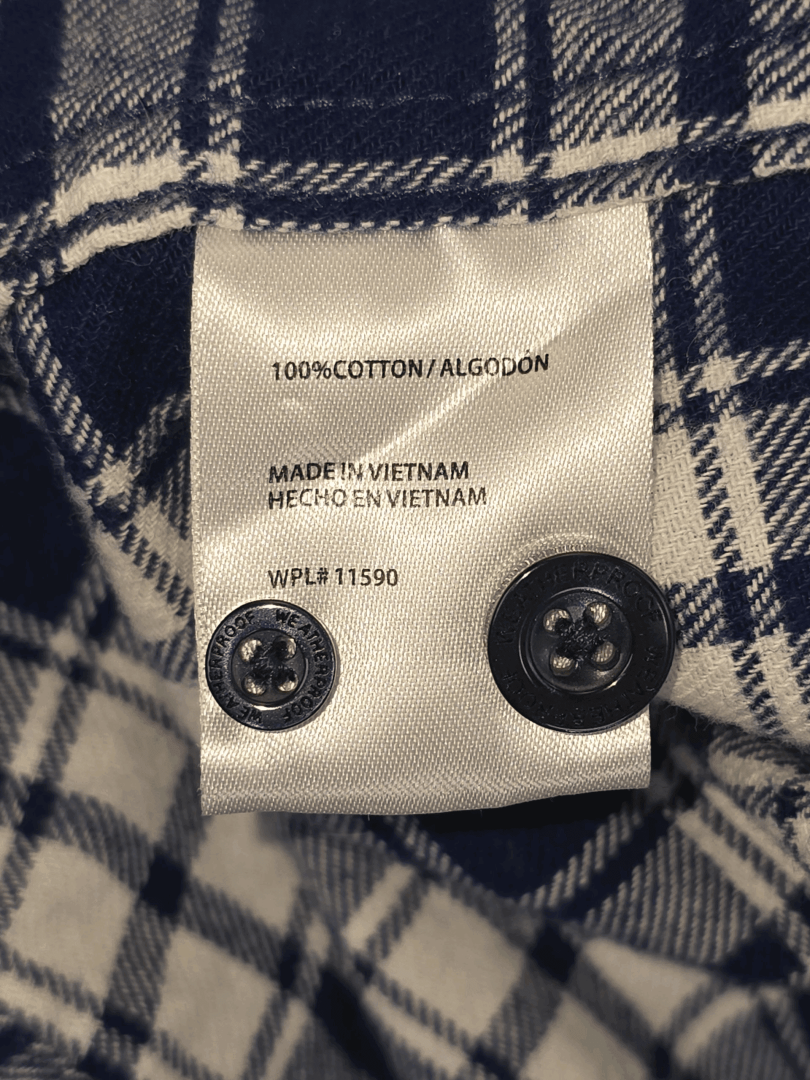 Close-up of a clothing label showing fabric and manufacturing details.