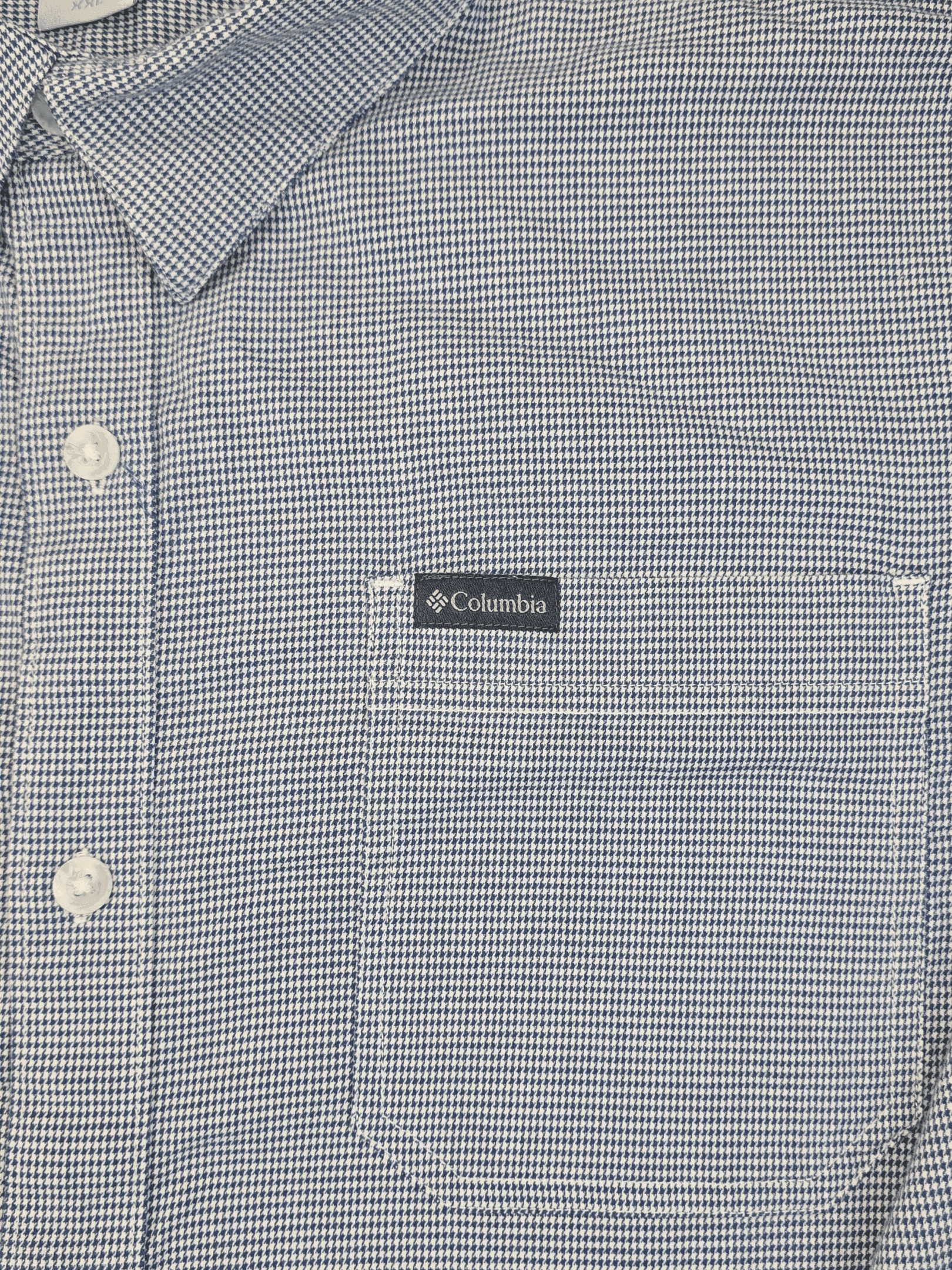 Close-up of a blue and white striped shirt pocket with Columbia label.