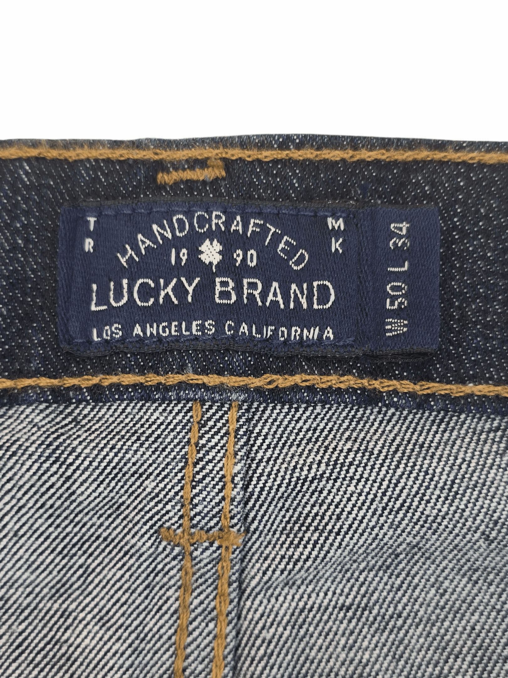 Close-up of Lucky Brand jeans label with size and handcrafted details.