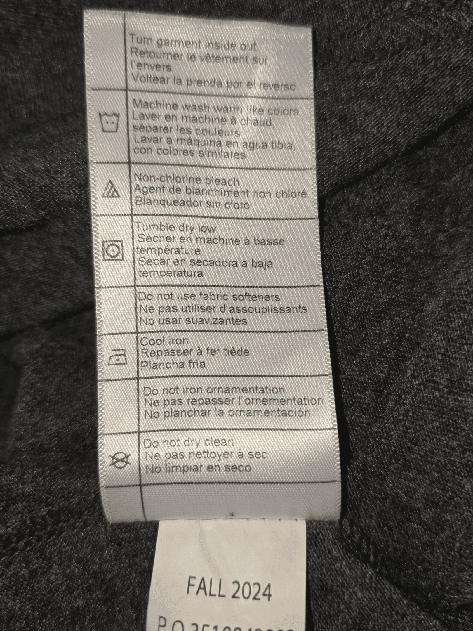 Care label with washing and ironing instructions on fabric.