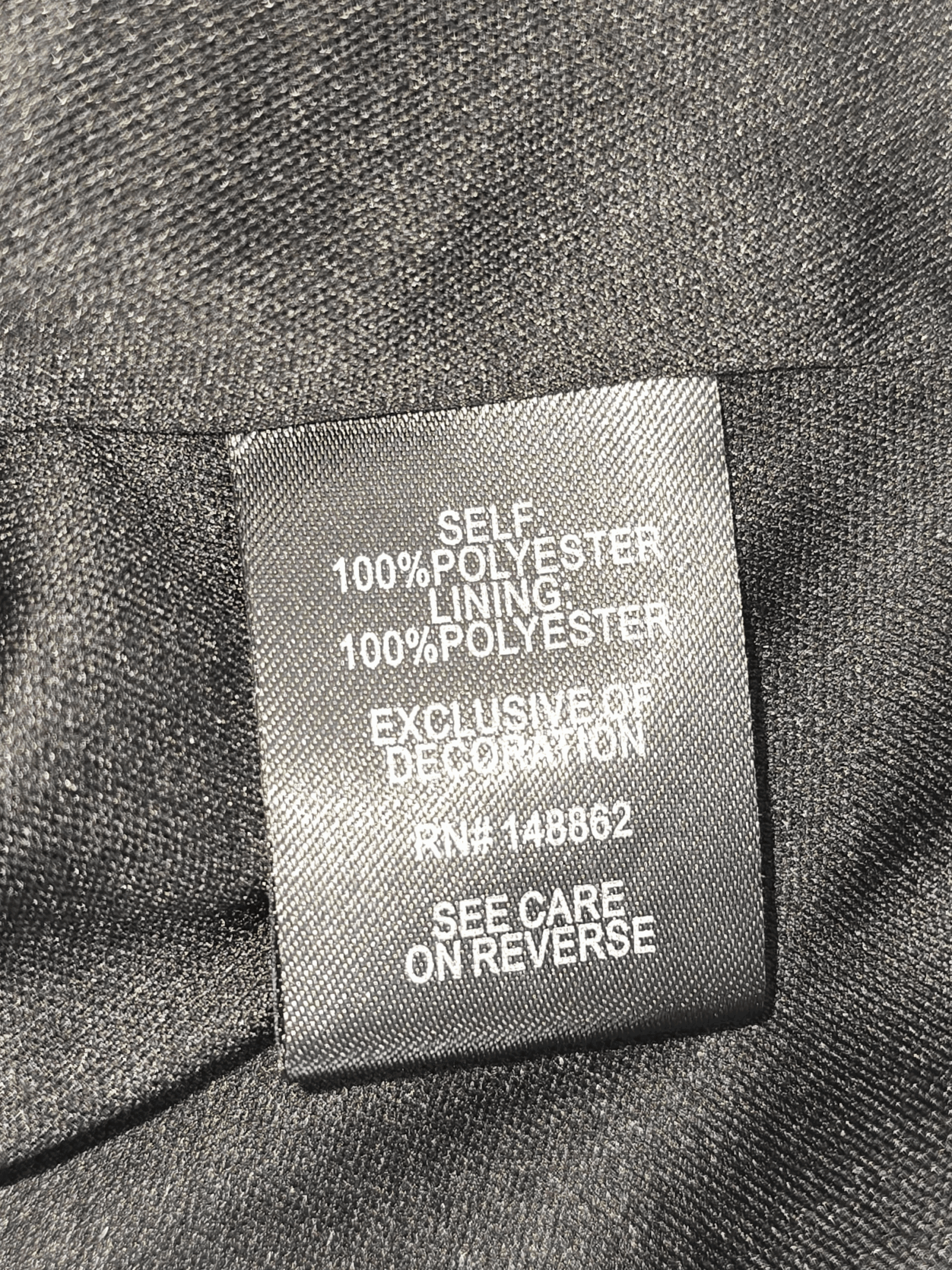 Clothing tag showing fabric and lining made of 100% polyester.