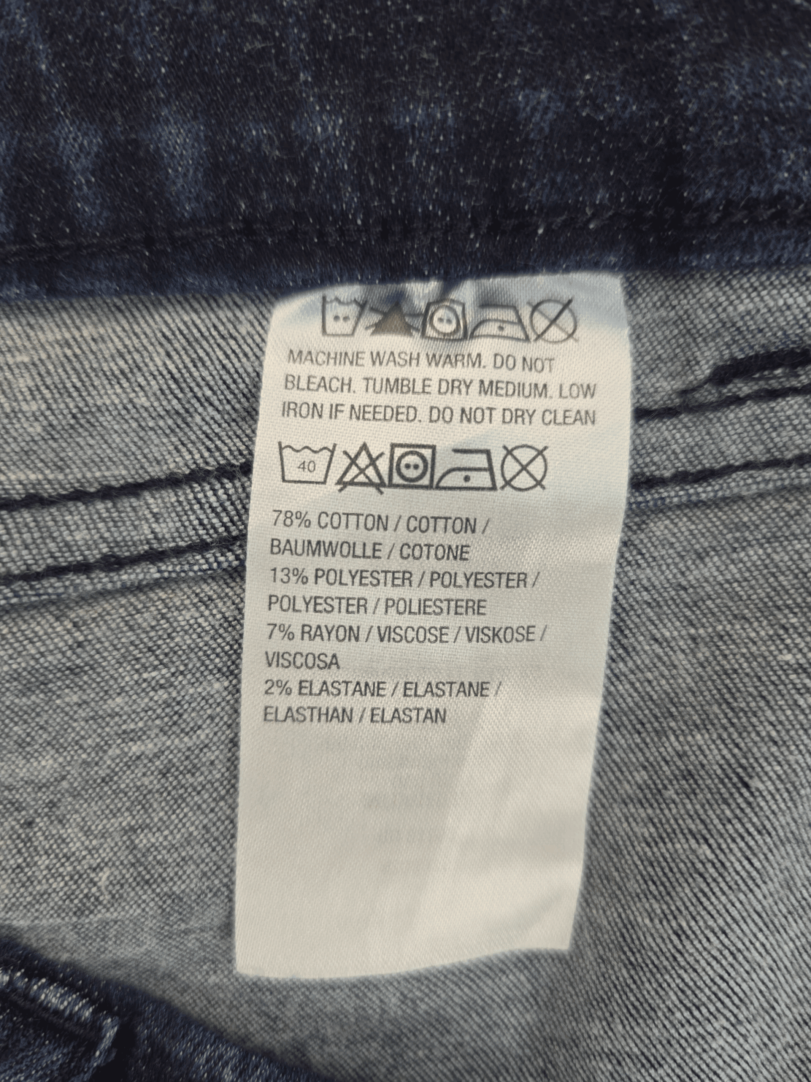 Material content tag listing cotton, polyester, and spandex blend for D&Co pull-on blue jeans.