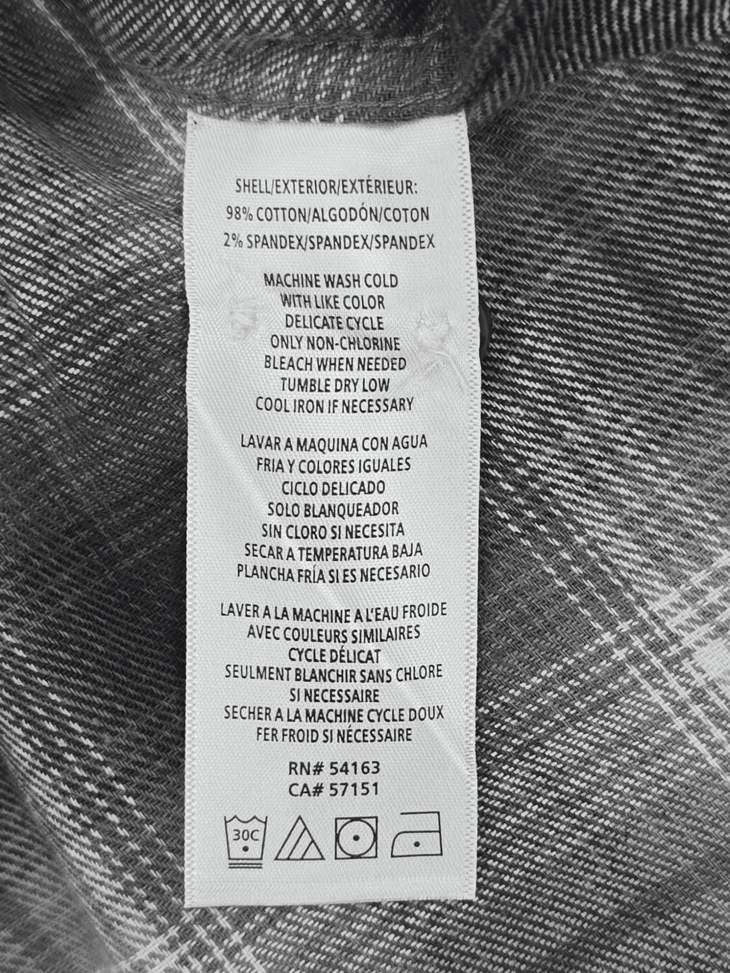 Material content tag listing 100% cotton for Bass Outdoor gray and white plaid flannel shirt.