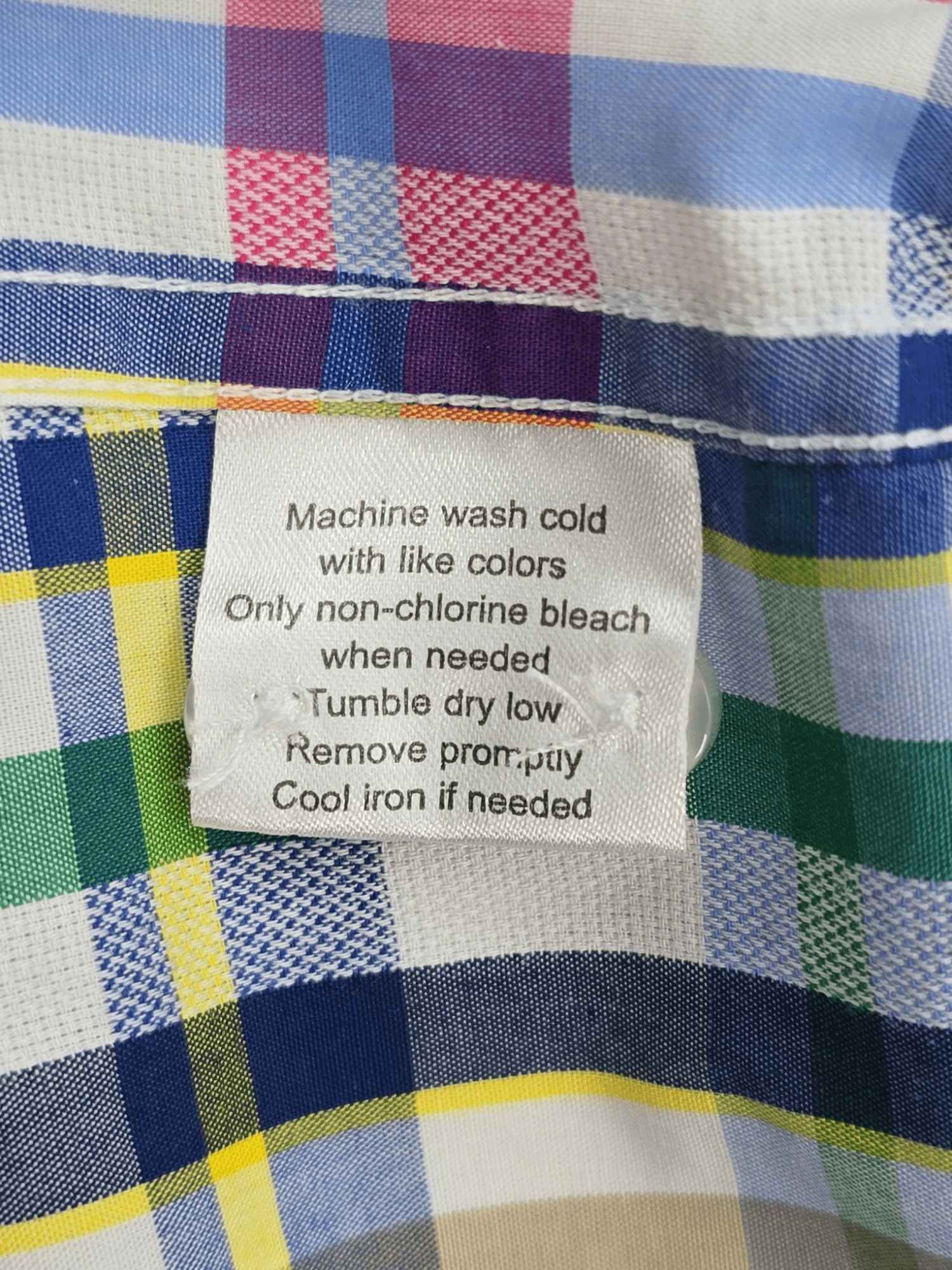 Garment care tag for Linea Uomo multicolored check short sleeve shirt showing washing and drying directions.