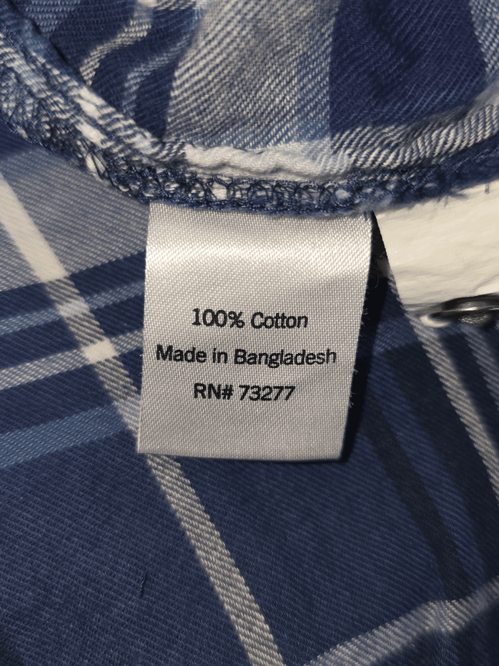 Material content tag listing 100% cotton for Sonoma blue and white plaid brushed cotton button-up shirt.