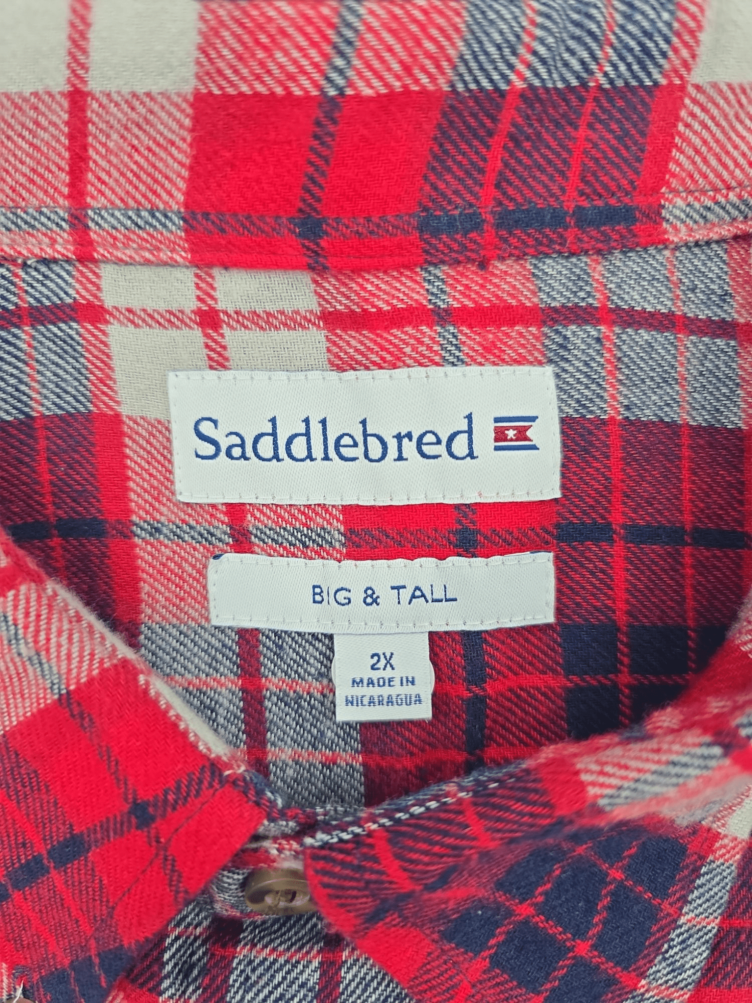 Saddlebred brand and size tag on Big & Tall red, blue, and gray plaid flannel shirt in men’s size 2X.