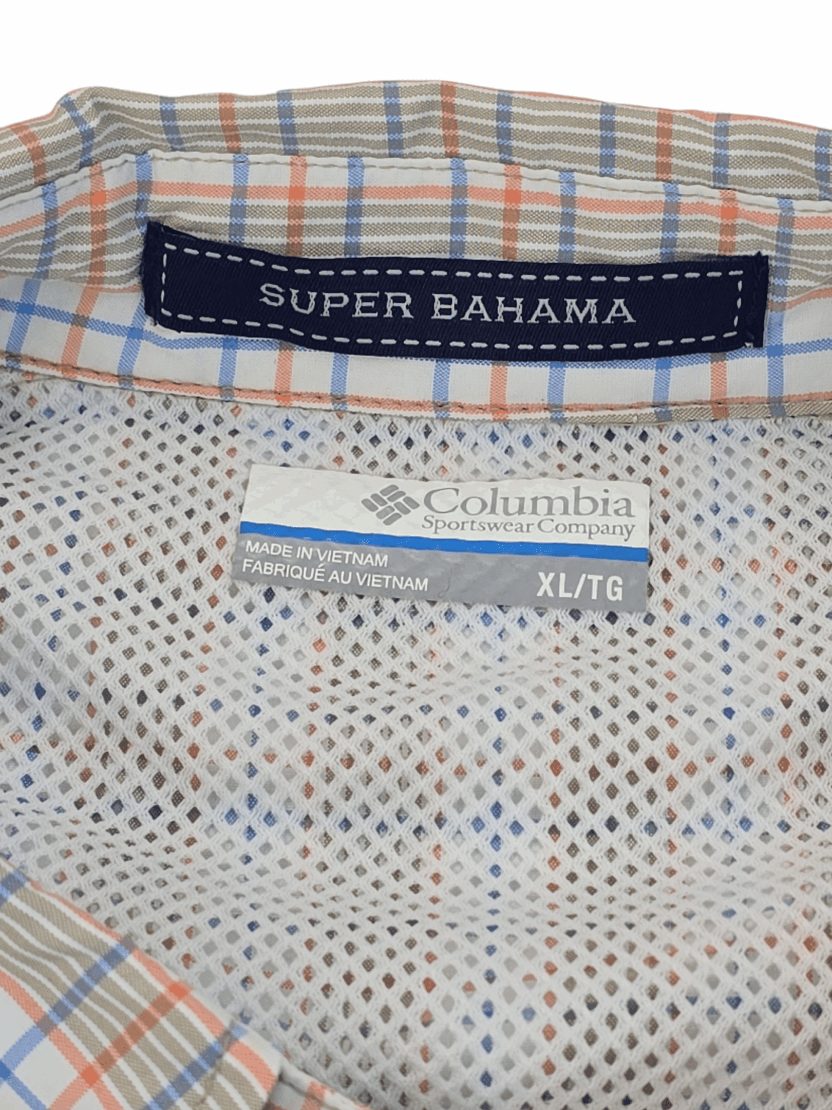 Close-up of clothing labels on a patterned fabric shirt.