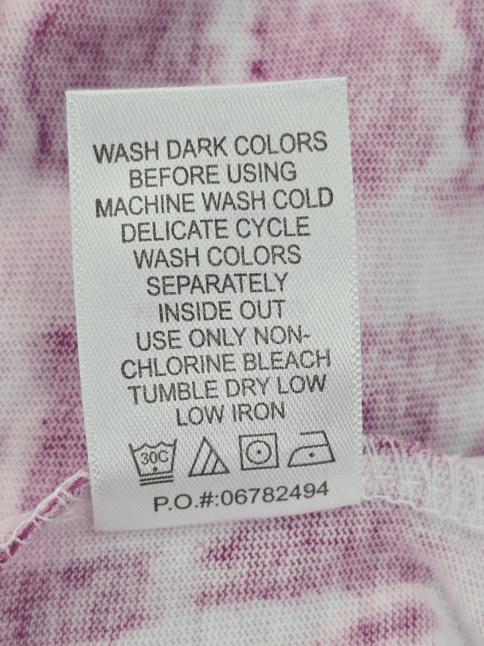Clothing care label with washing and ironing instructions.