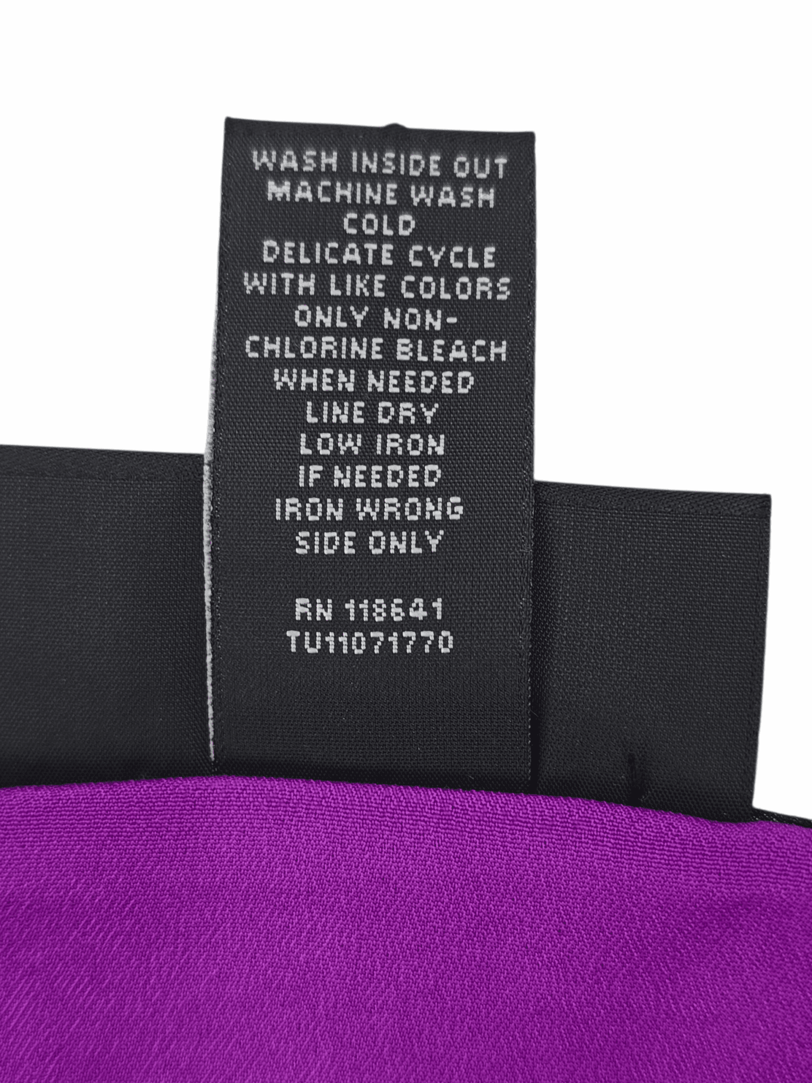 Clothing care label with detailed washing instructions and fabric content.