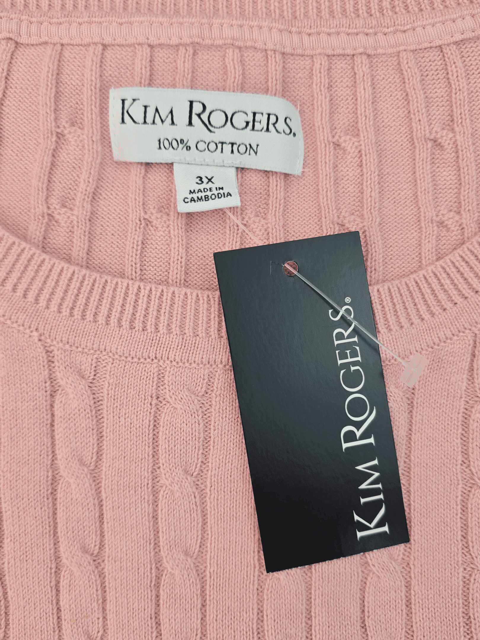 Close-up of a pink Kim Rogers sweater label and tag.