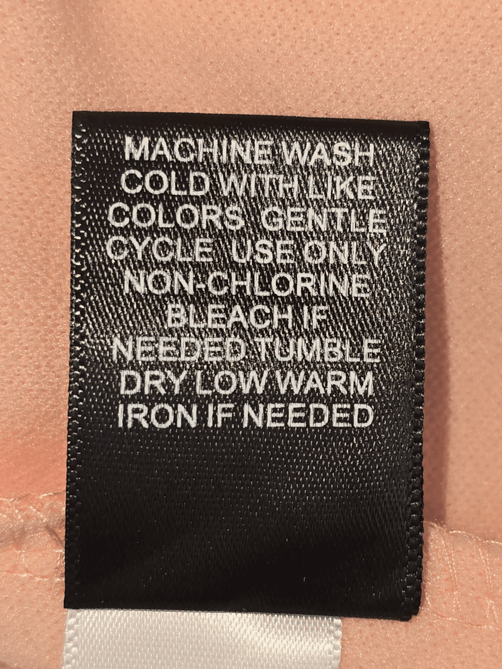 Clothing care label with washing and ironing instructions.